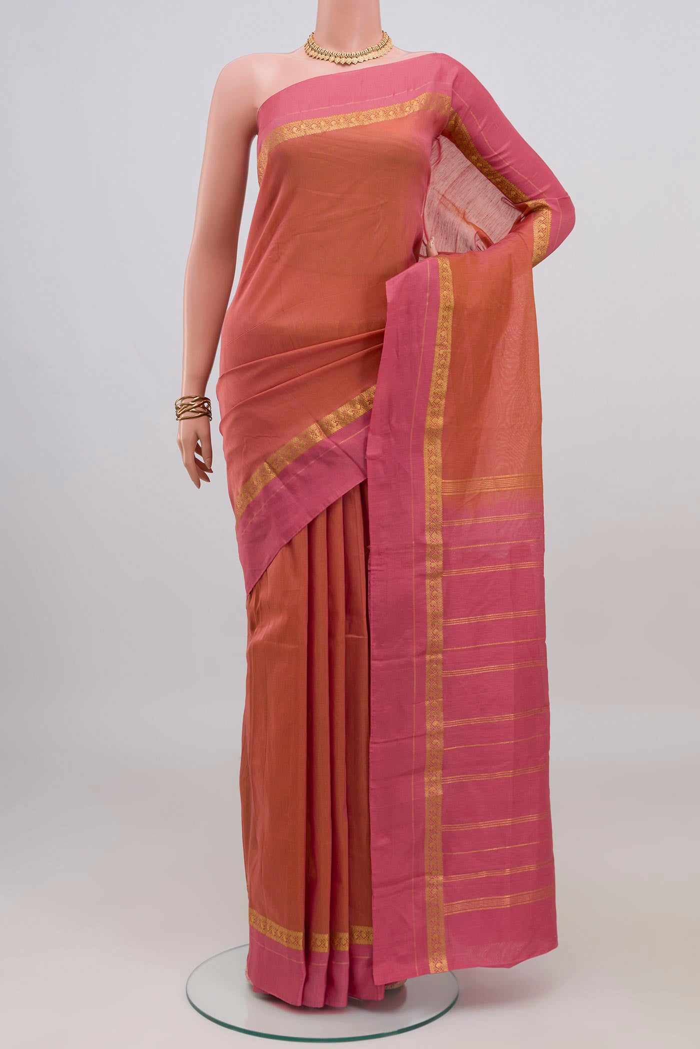 Peach Kanchi Cotton Saree with Plain Body and Thin Zari Line.  displayed on a mannequin
