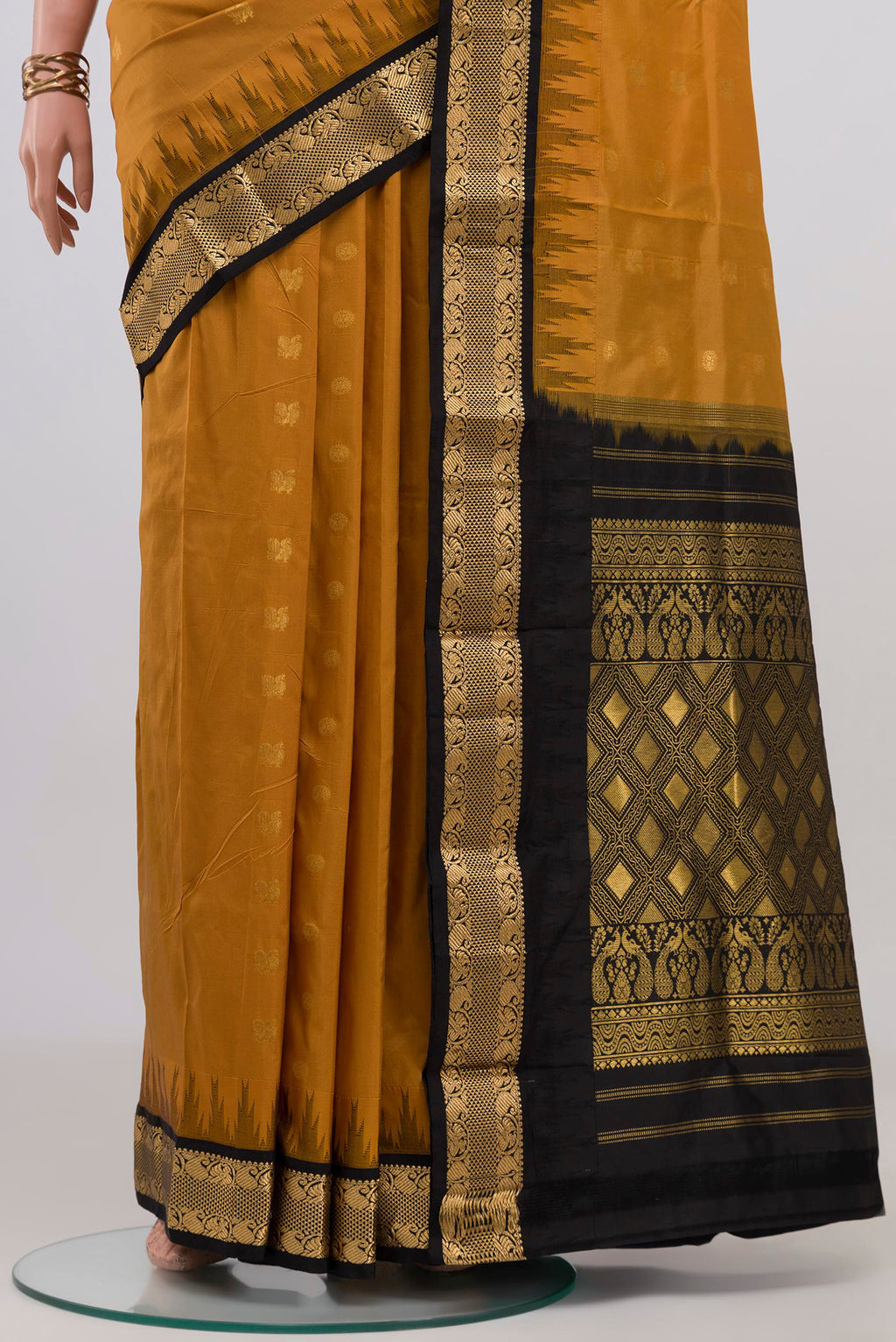 Pleats and pallu of Mustard Bangalore Silk Saree with Zari Butta on the body and Zari Border. 