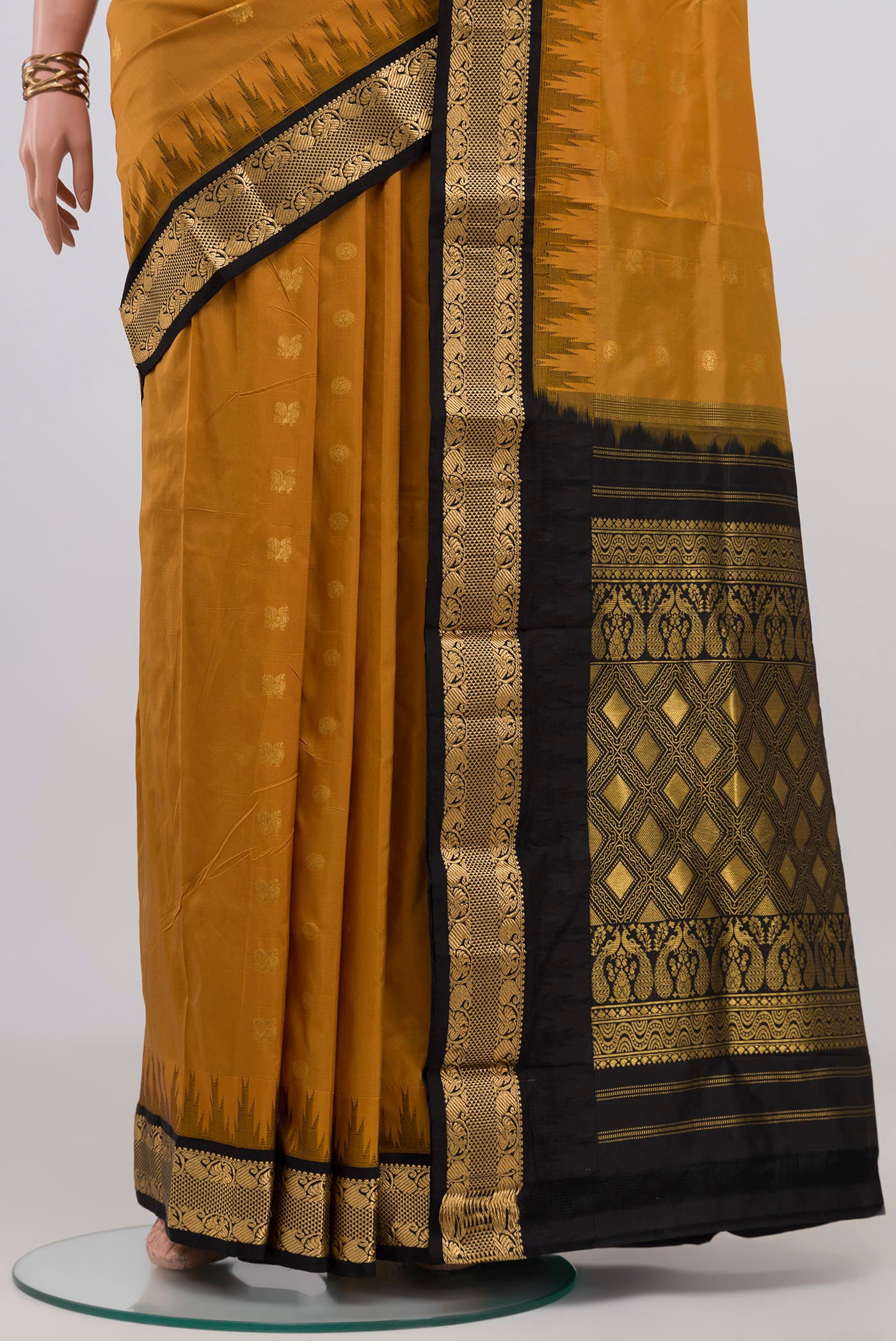 Pleats and pallu of Mustard Bangalore Silk Saree with Zari Butta on the body and Zari Border. 