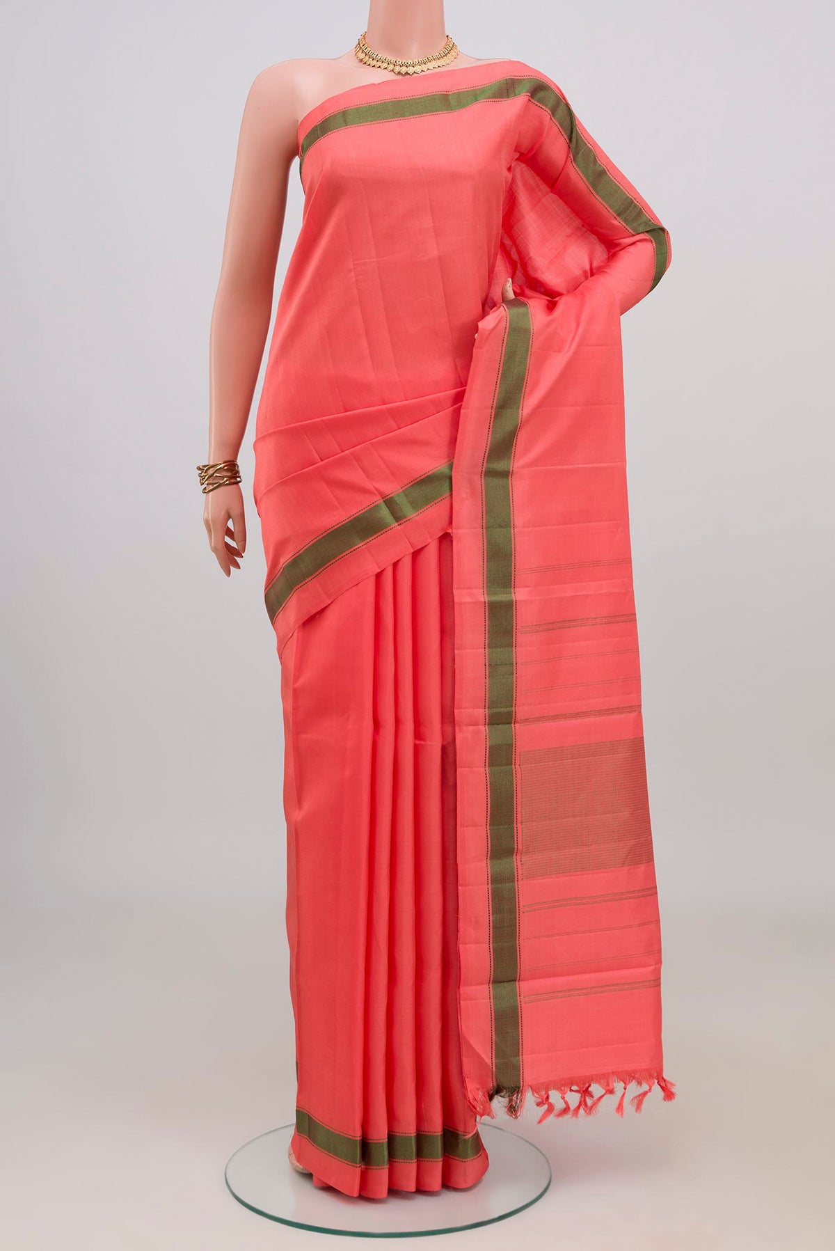Peach Kanchipuram Silk Saree with Plain Body and Thread Border.  displayed on a mannequin