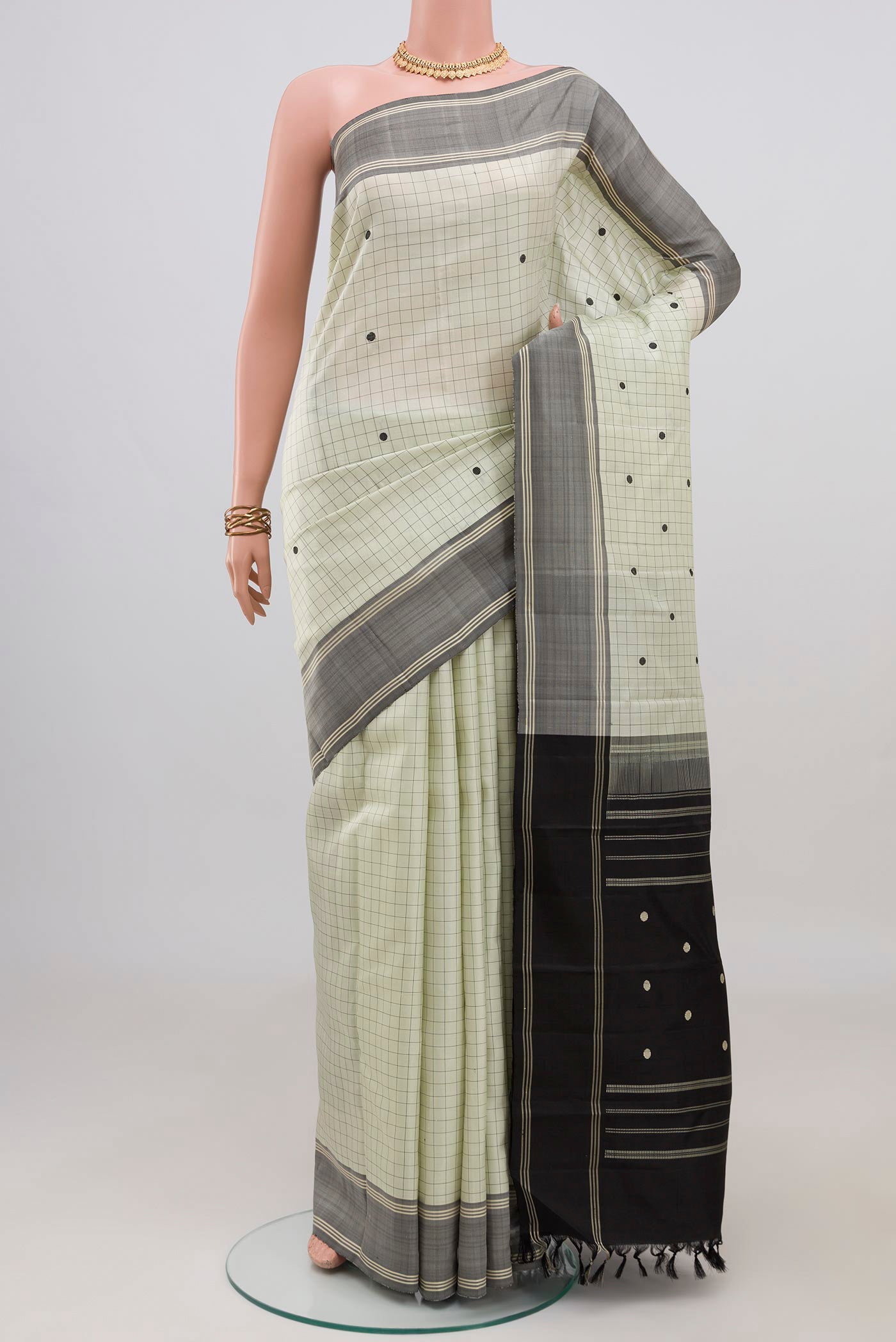 Off White Kanchipuram Silk Saree with Checked design on the body and Plain Border.  displayed on a mannequin