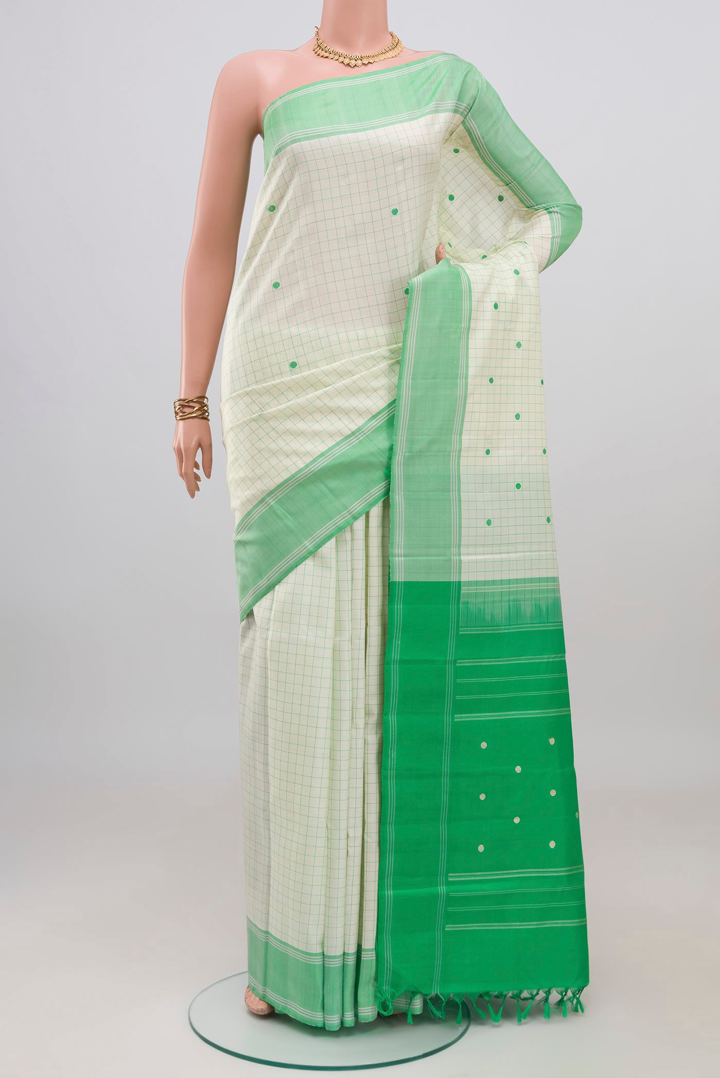 Off White Kanchipuram Silk Saree with Checked design on the body and Plain Border.  displayed on a mannequin