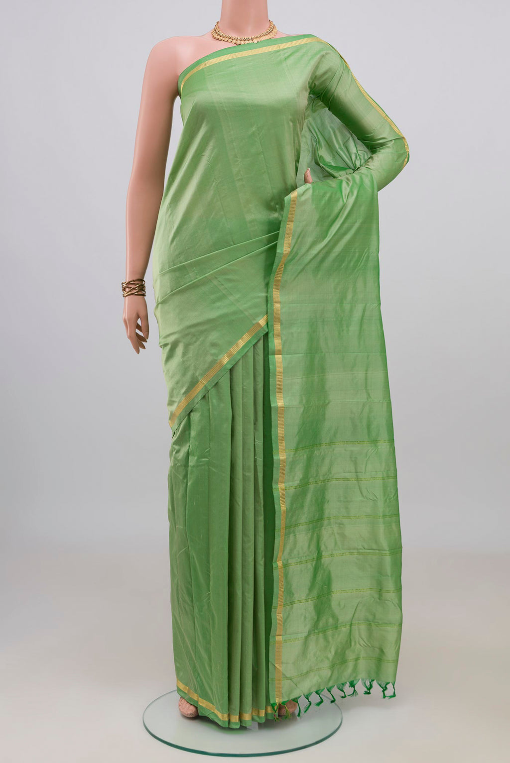 Pure Silk Green Kanchipuram Saree with Plain Body and Zari Border.  displayed on a mannequin