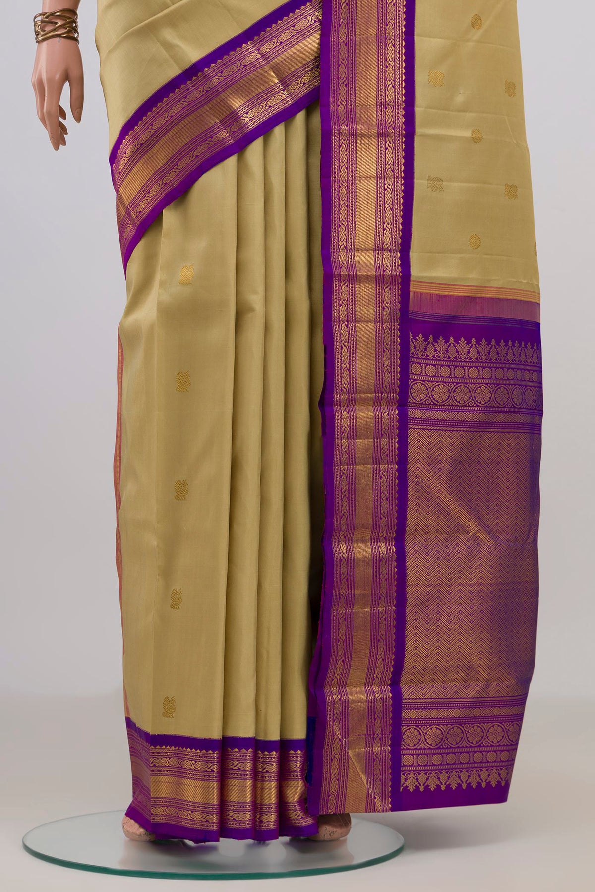 Pleats and pallu of Pure Silk Pure Zari Sandal Kanchipuram Saree with Zari Butta on the body and Zari Border. 