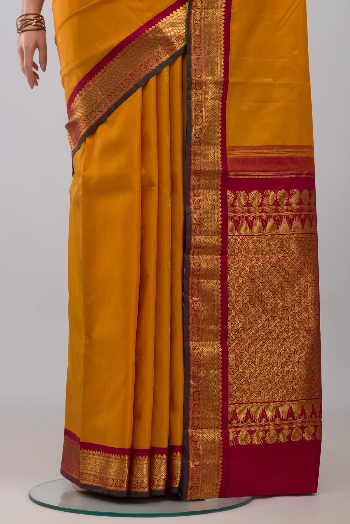 Pleats and pallu of Yellow Kanchipuram Silk Saree with Zari Butta on the body and Zari Border. 