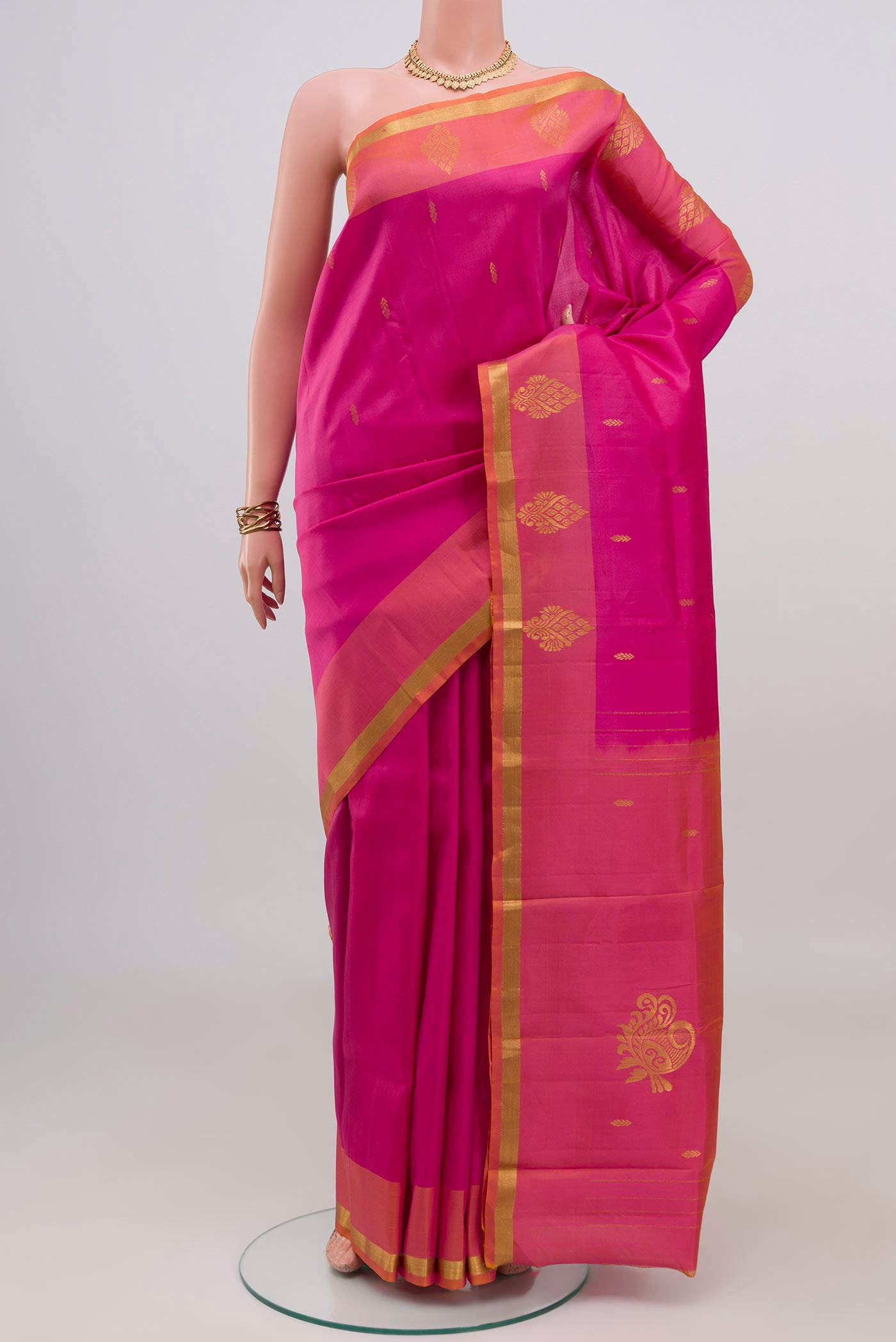Pink Kanchipuram Silk Saree with Zari Butta on the body and Zari Border.  displayed on a mannequin