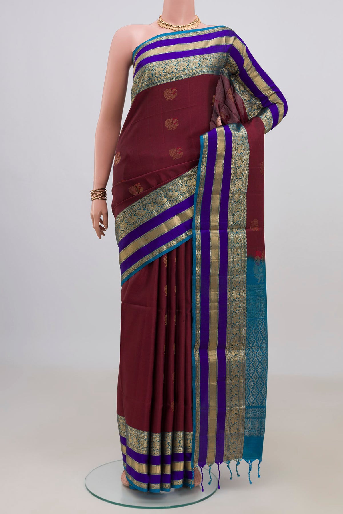 Pure Silk Maroon Soft Saree with Zari Butta on the body and Zari Border.  displayed on a mannequin