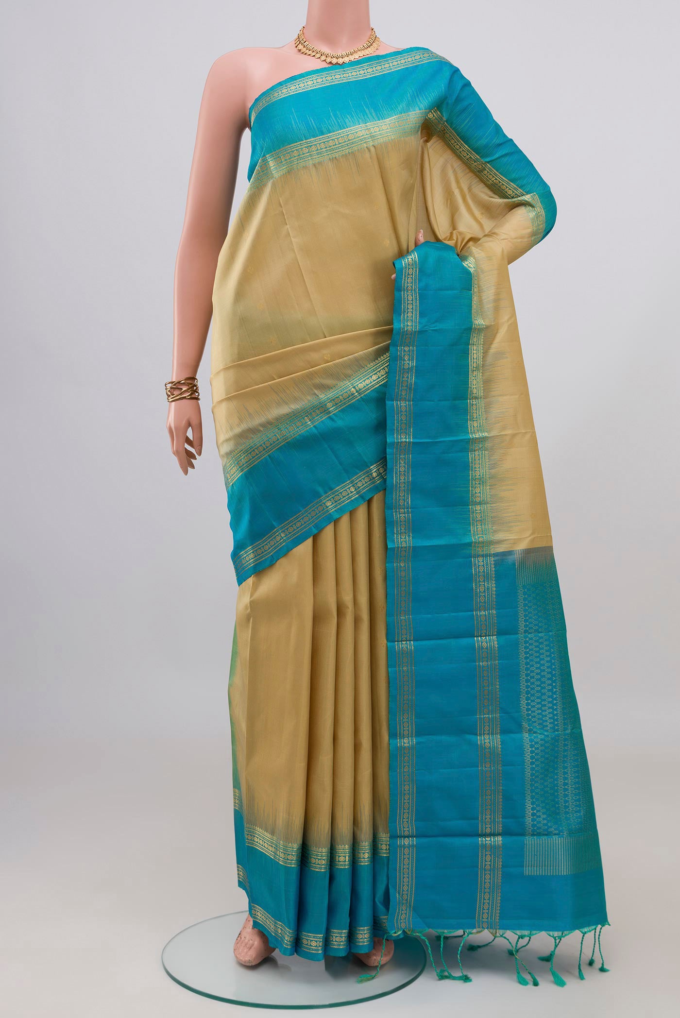 Beige Soft Silk Saree with Zari Butta on the body and Zari Border.  displayed on a mannequin