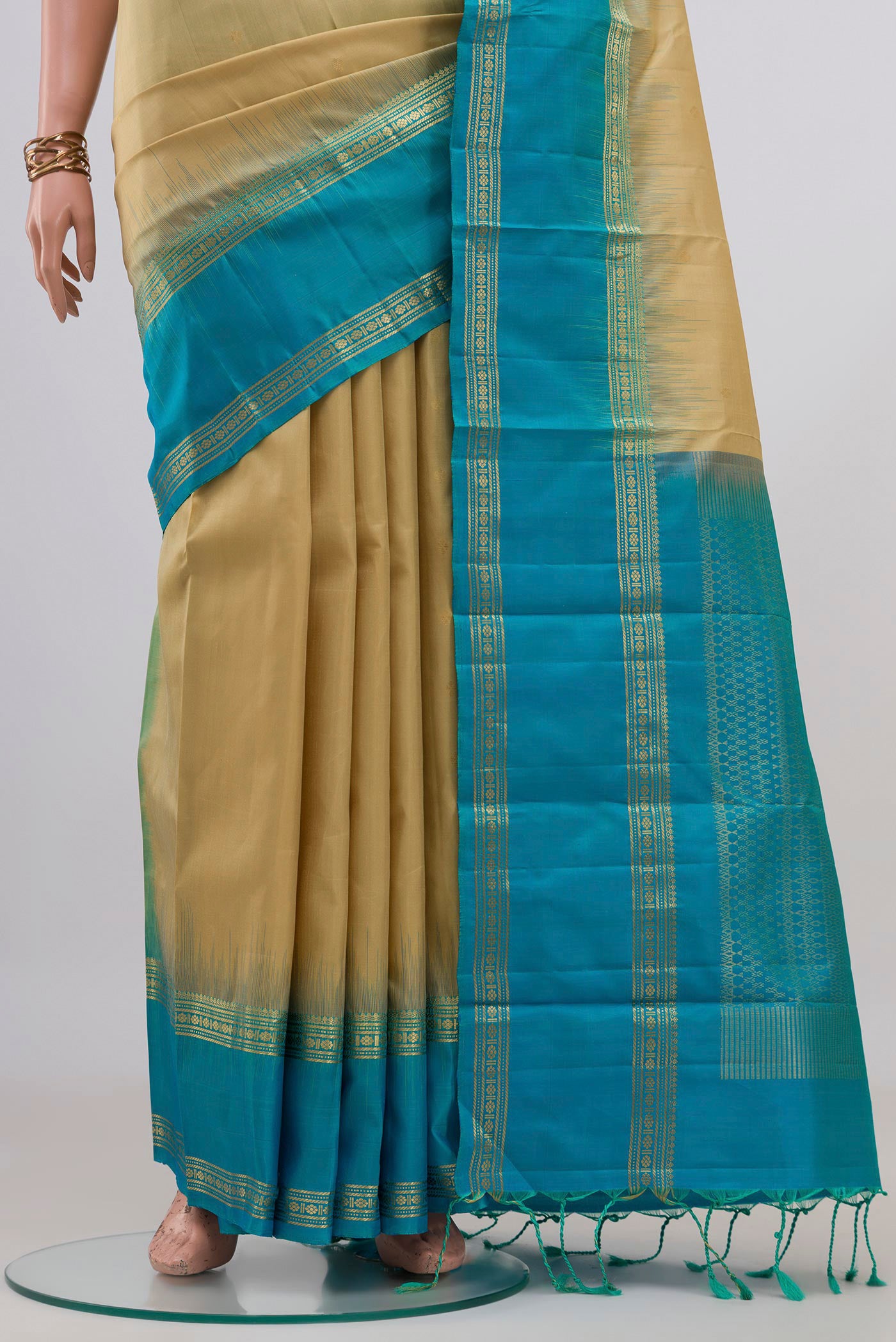 Pleats and pallu of Beige Soft Silk Saree with Zari Butta on the body and Zari Border. 