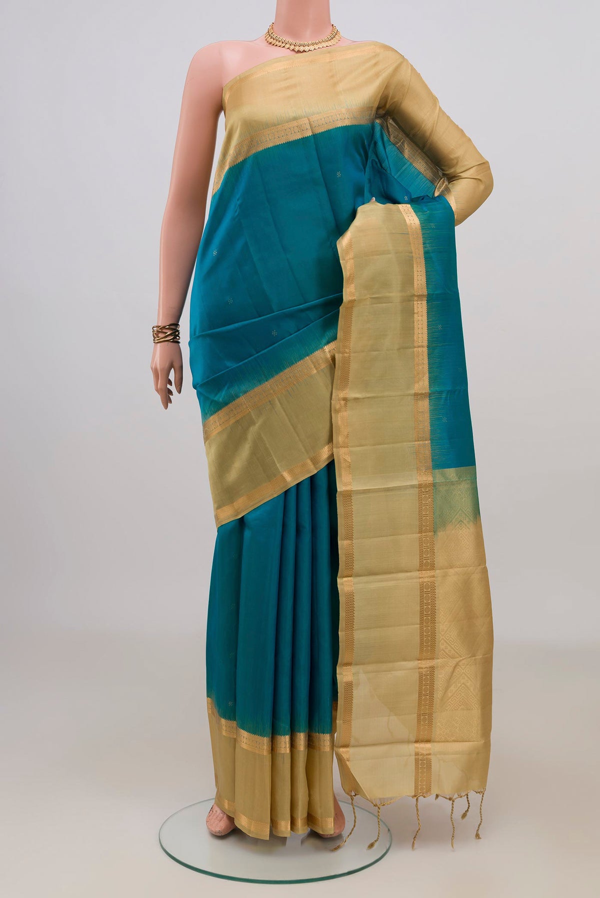 Pure Silk Blue Kanjivaram Saree with Zari Butta on the body and Zari Border.  displayed on a mannequin