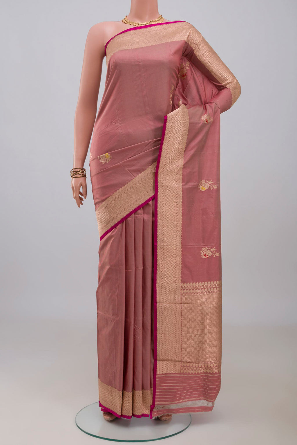 Rose Gold Banarasi Katan Silk Saree with Zari Butta on the body and Zari Border.  displayed on a mannequin