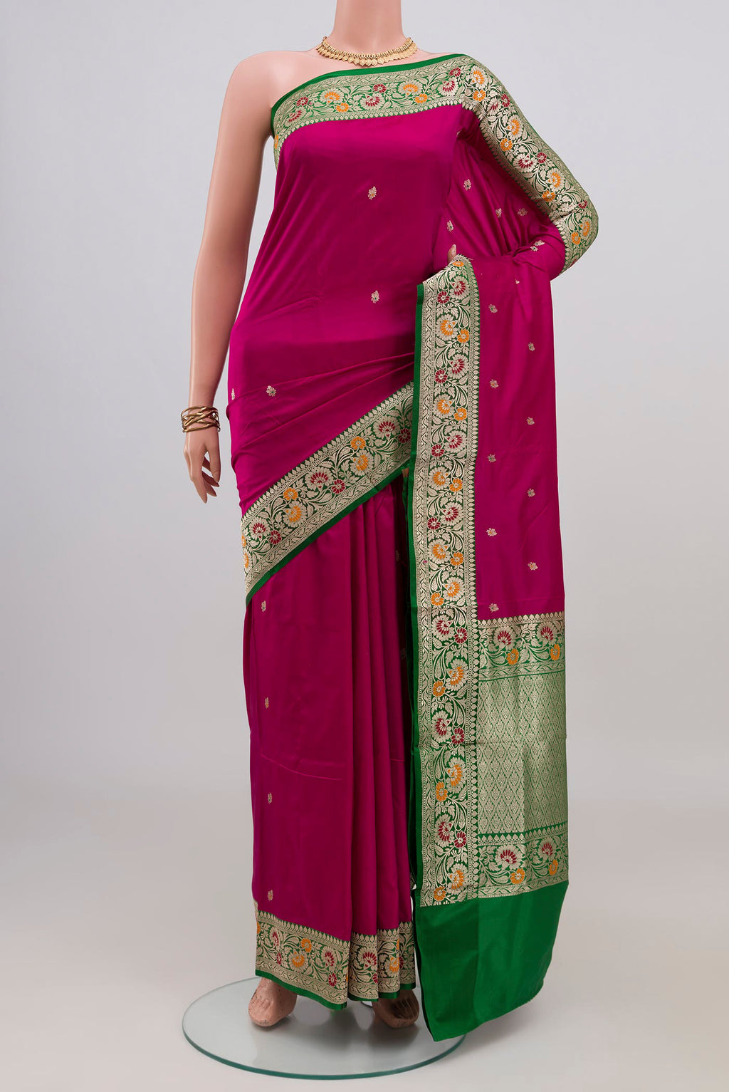 Magenta Banarasi Katan Silk Saree with Zari Butta on the body and Fancy Border.  displayed on a mannequin