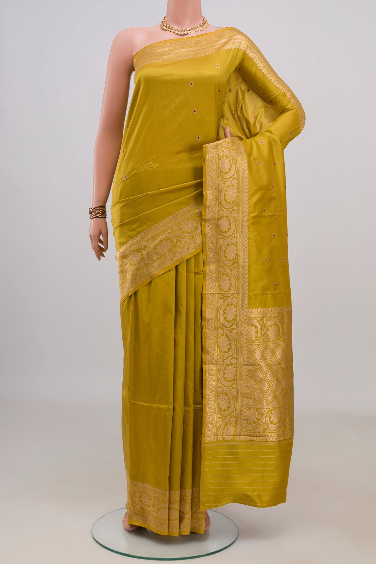 Pure Silk Mustard Banarasi Katan Saree with Zari Butta on the body and Zari Border.  displayed on a mannequin