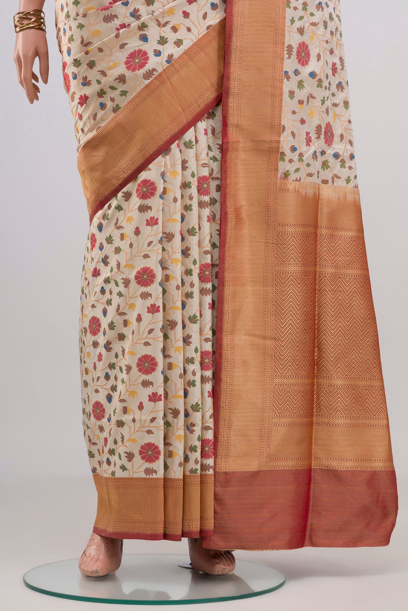Pleats and pallu of Cream Banarasi Silk Saree with Zari And Thread Butta on the body and Zari Border. 