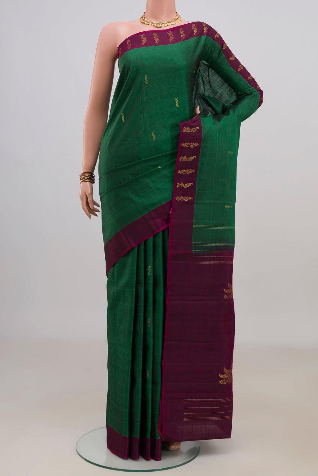 Pure Silk Green Kanchipuram Saree with Zari Butta on the body and Fancy Border.  displayed on a mannequin