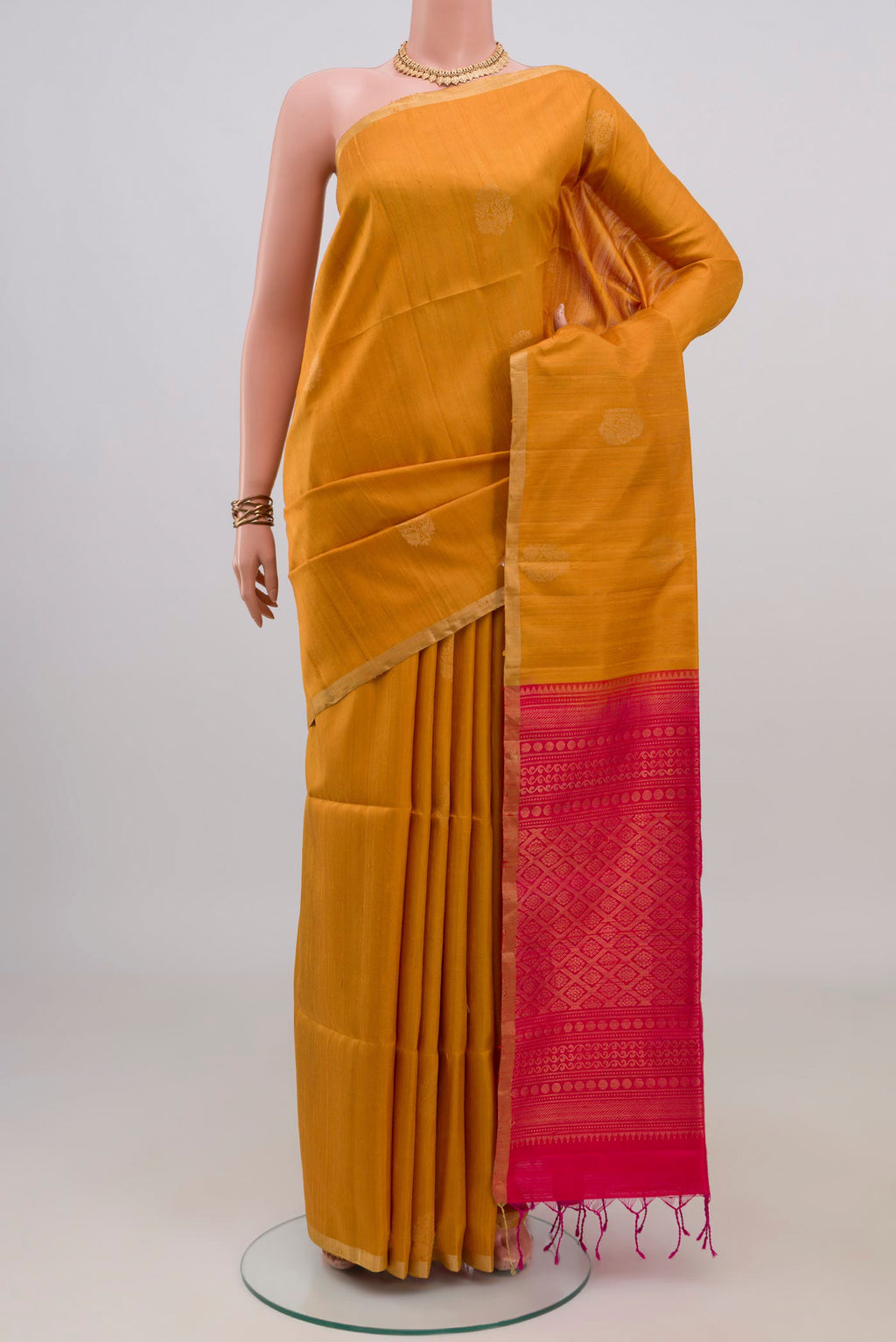 Pure Silk Mustard Soft Saree with Zari Butta on the body and Zari Border.  displayed on a mannequin