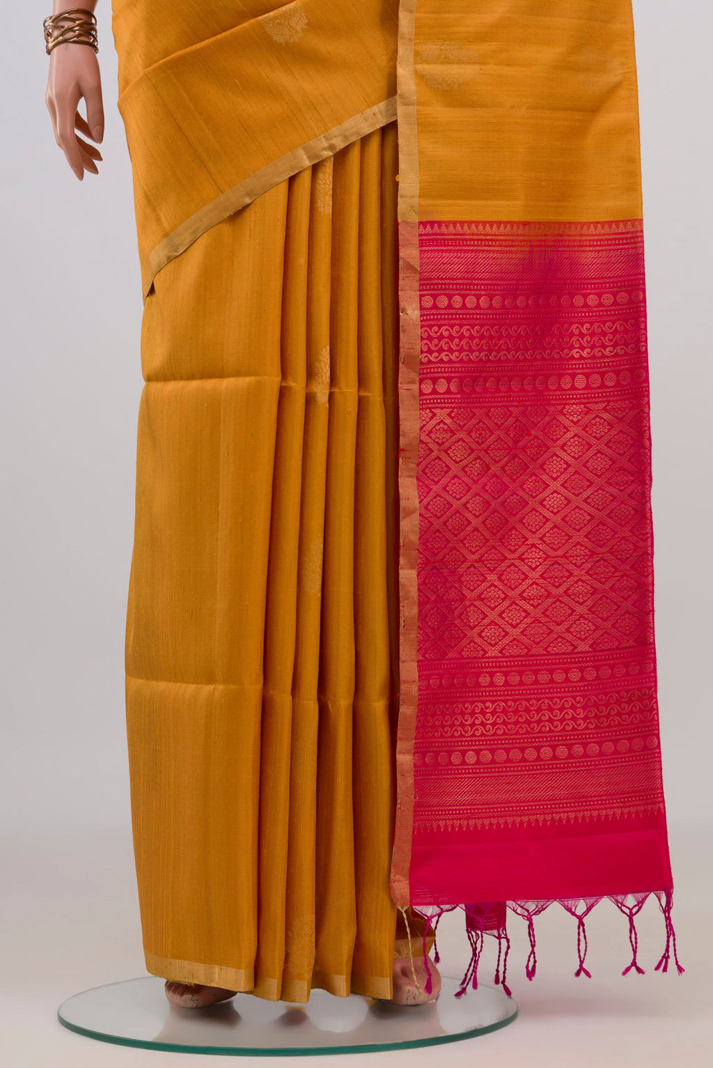 Pleats and pallu of Pure Silk Mustard Soft Saree with Zari Butta on the body and Zari Border. 
