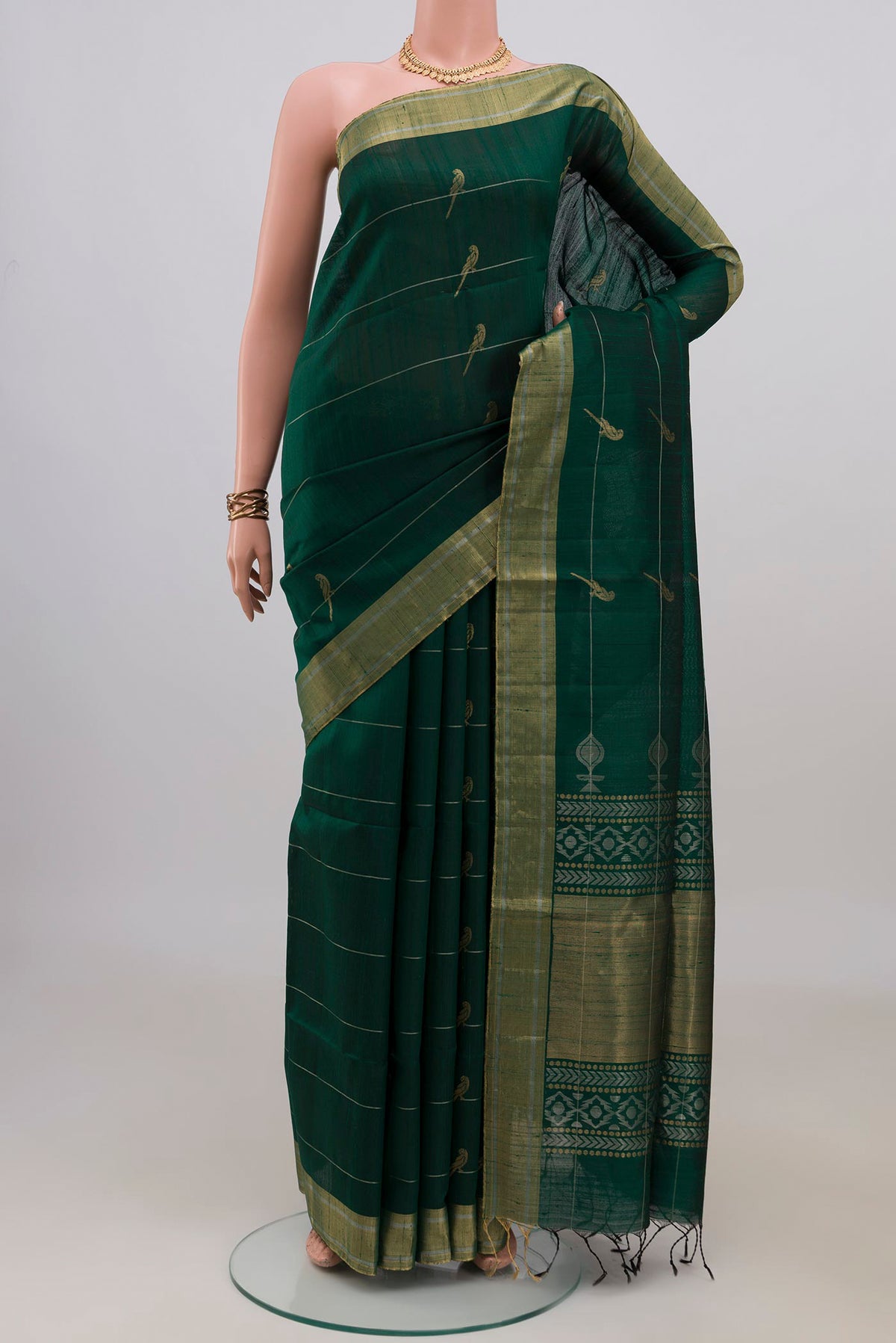 Pure Silk Bottle Green Raw Saree with Stripes on the body and Zari Border.  displayed on a mannequin