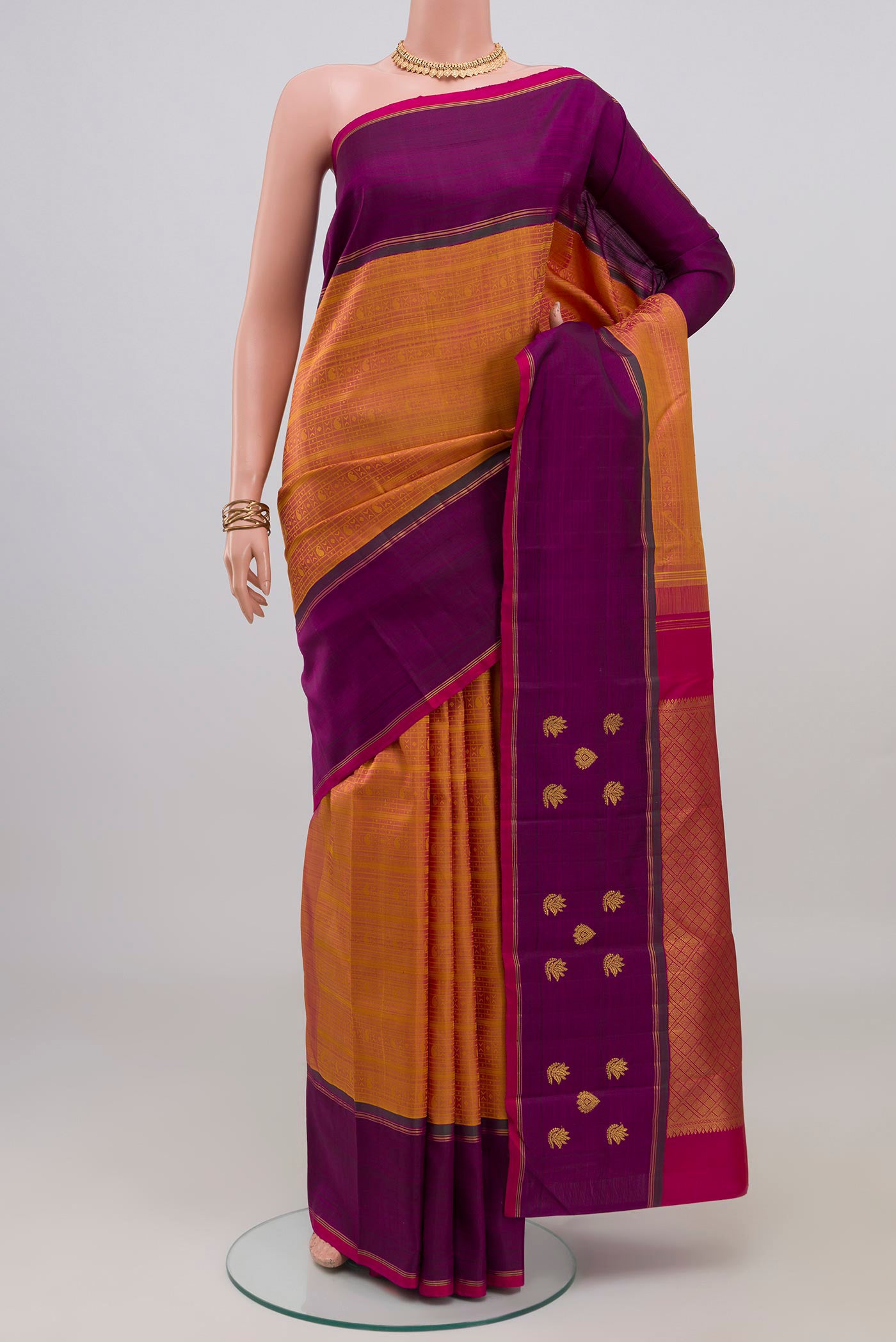 Mustard Kanchipuram Silk Saree with Jacquard design on the body and Plain Border.  displayed on a mannequin