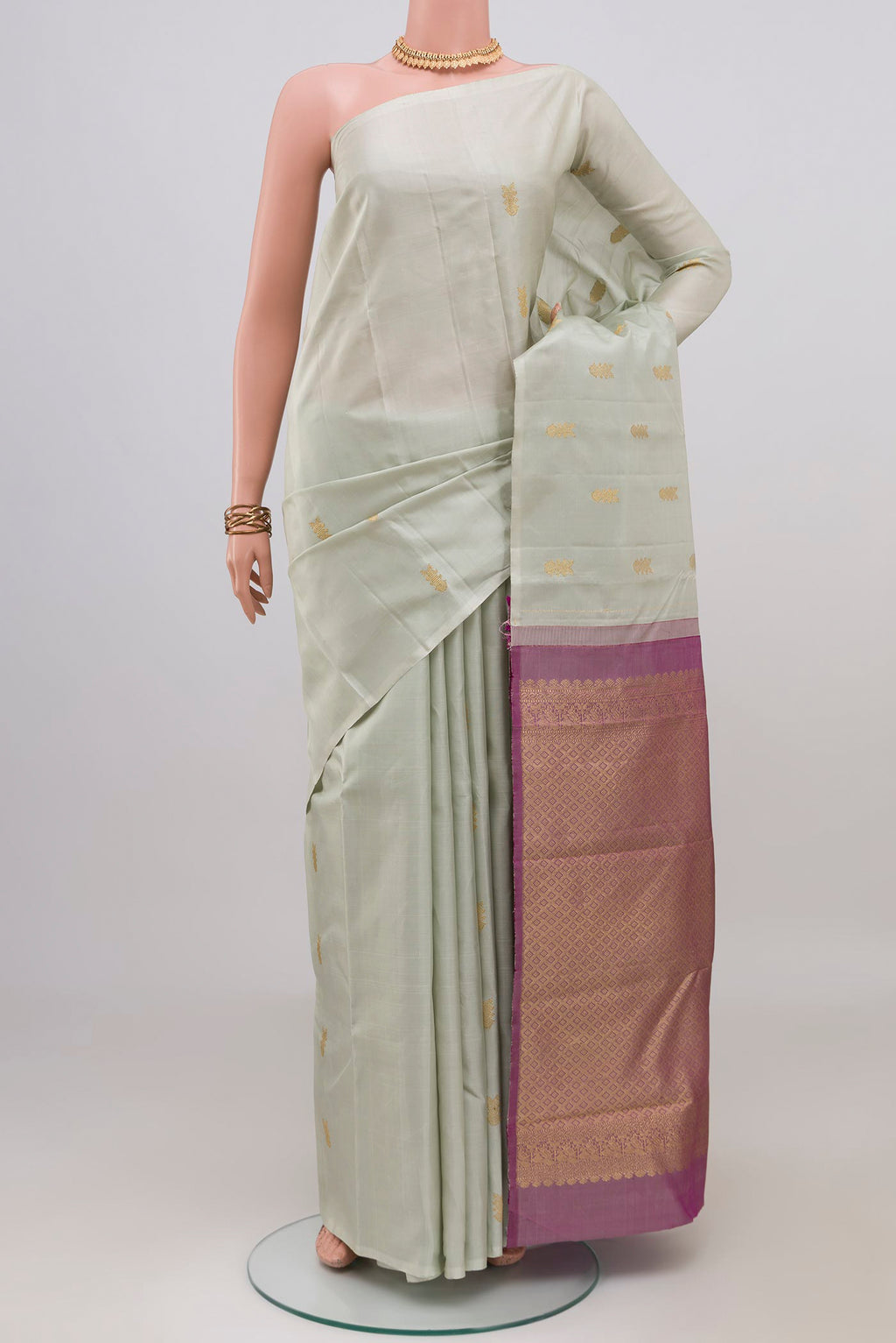 Cream Kanchipuram Silk Saree with Zari Butta on the body and Without Border.  displayed on a mannequin