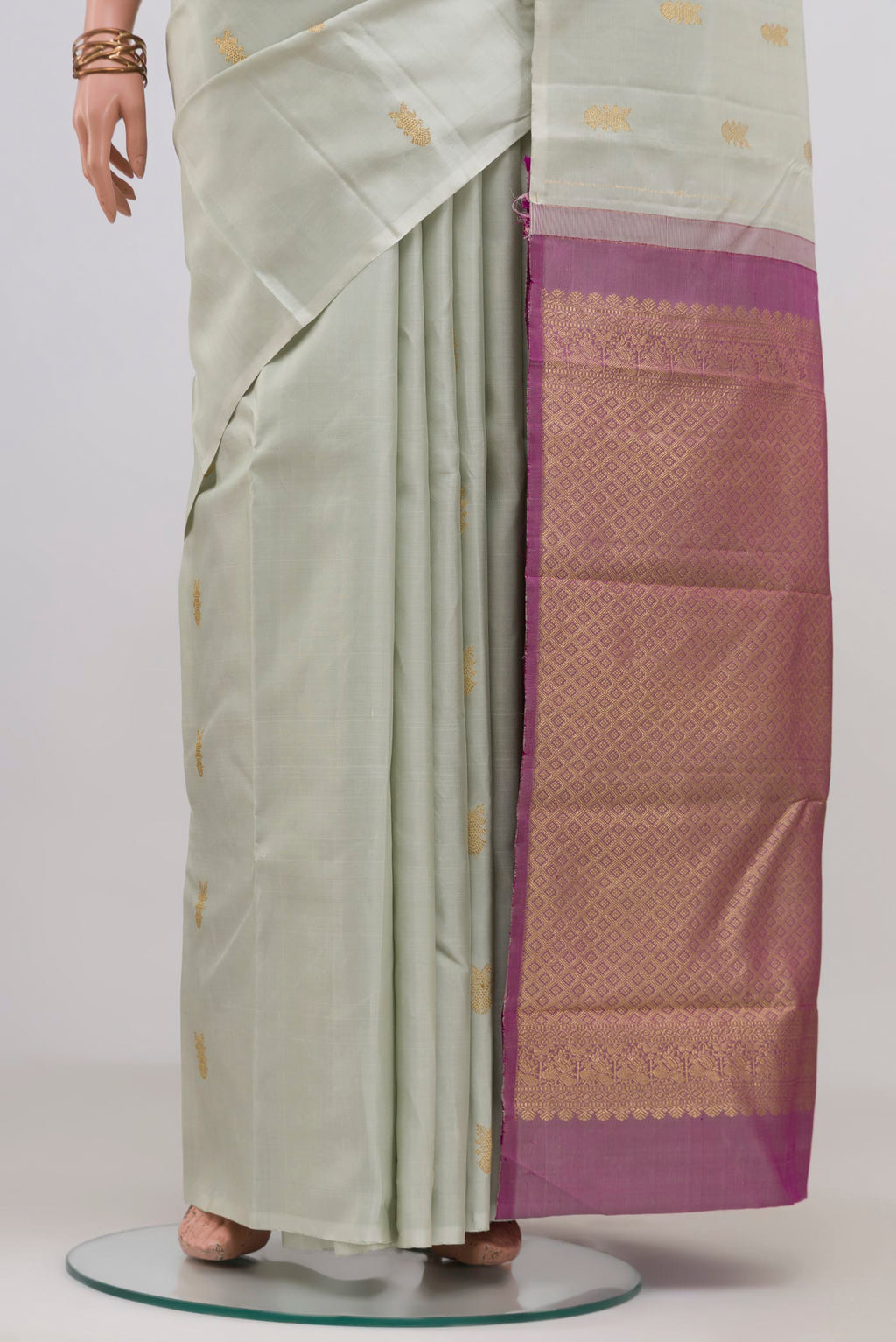Pleats and pallu of Cream Kanchipuram Silk Saree with Zari Butta on the body and Without Border. 