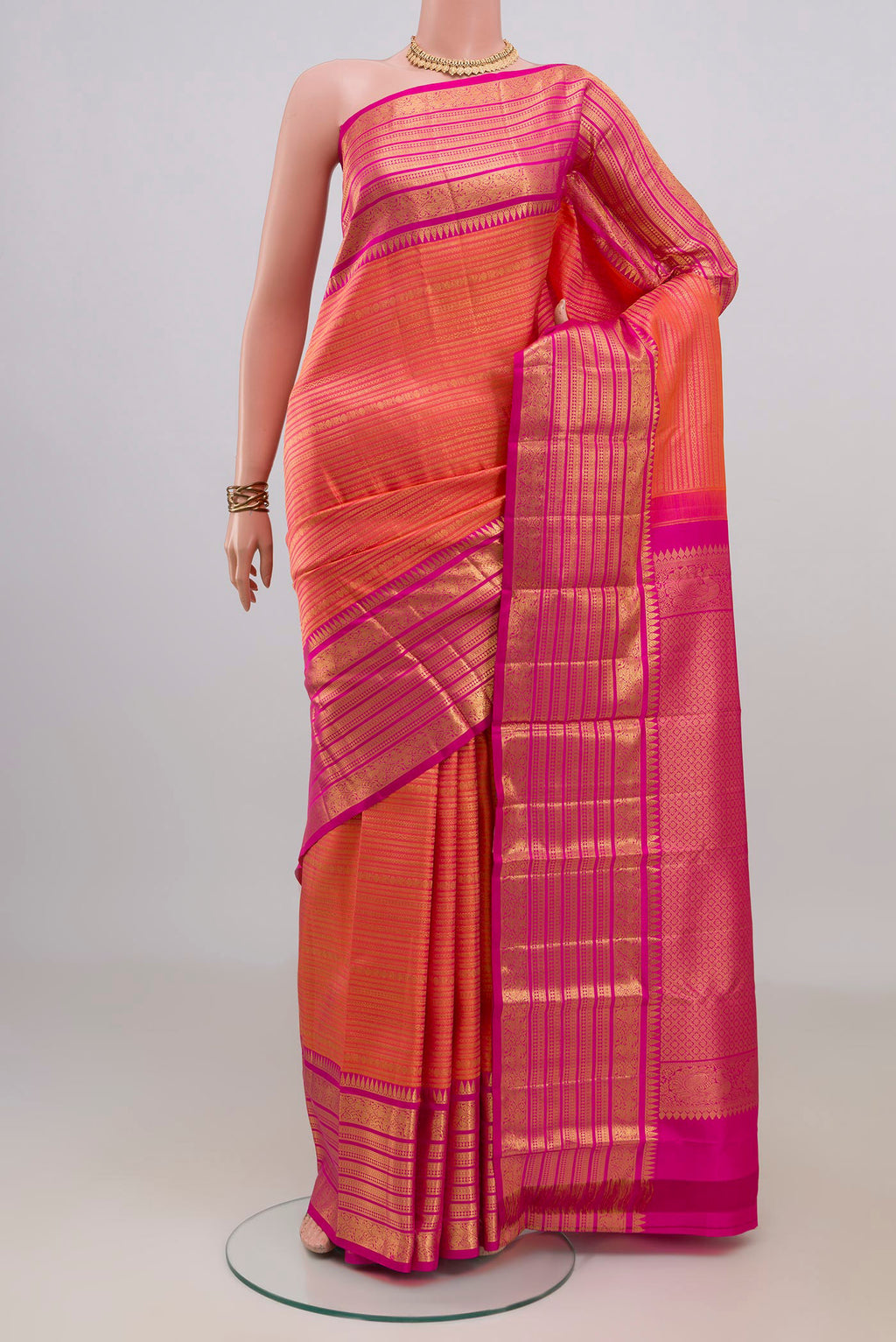 Pure Silk Coral Kanjivaram Saree with Zari Brocade on the body and Zari Border.  displayed on a mannequin
