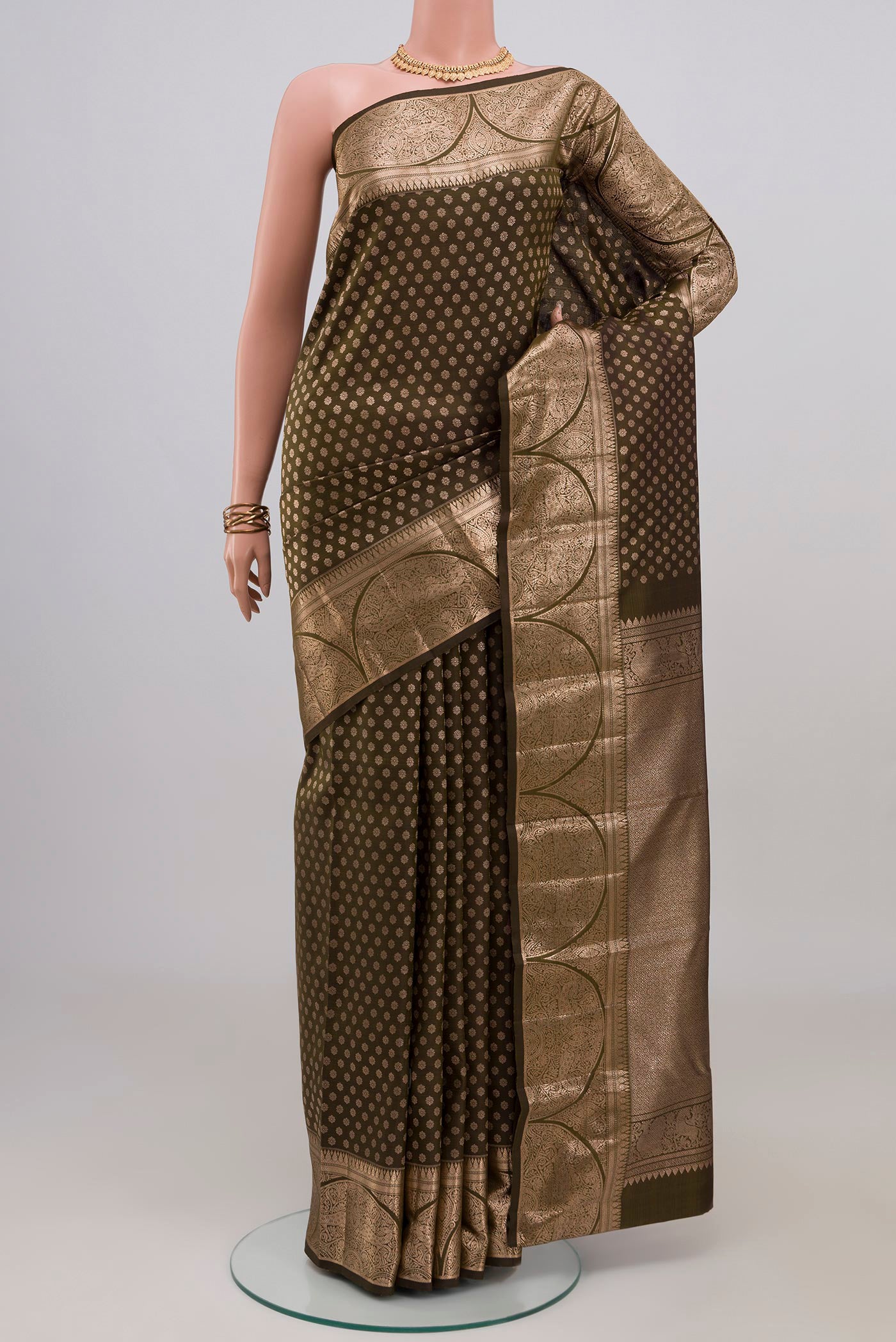 Mehandi Green Kanjivaram Silk Saree with Zari Butta on the body and Zari Border.  displayed on a mannequin