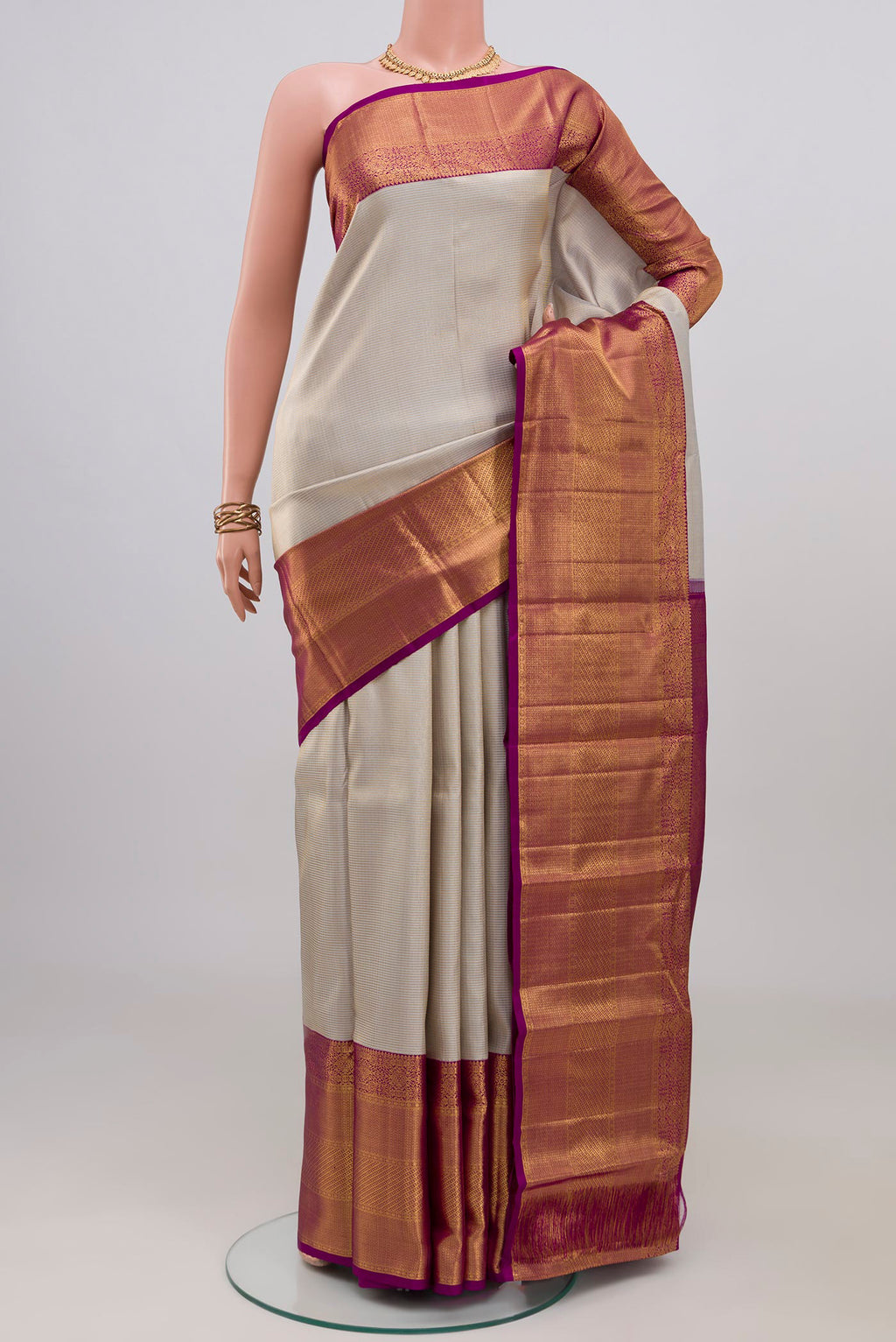 Off White Kanchipuram Silk Saree with Zari Brocade on the body and Zari Border.  displayed on a mannequin