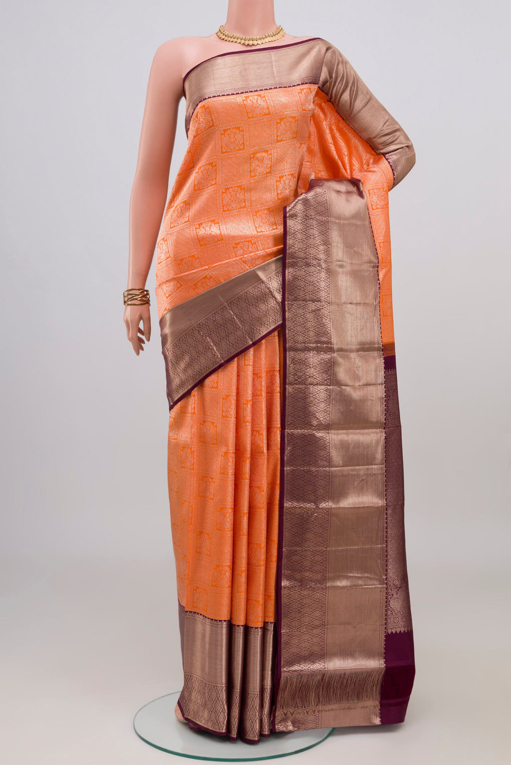 Orange Kanchipuram Silk Saree with Zari Brocade on the body and Zari Border.  displayed on a mannequin