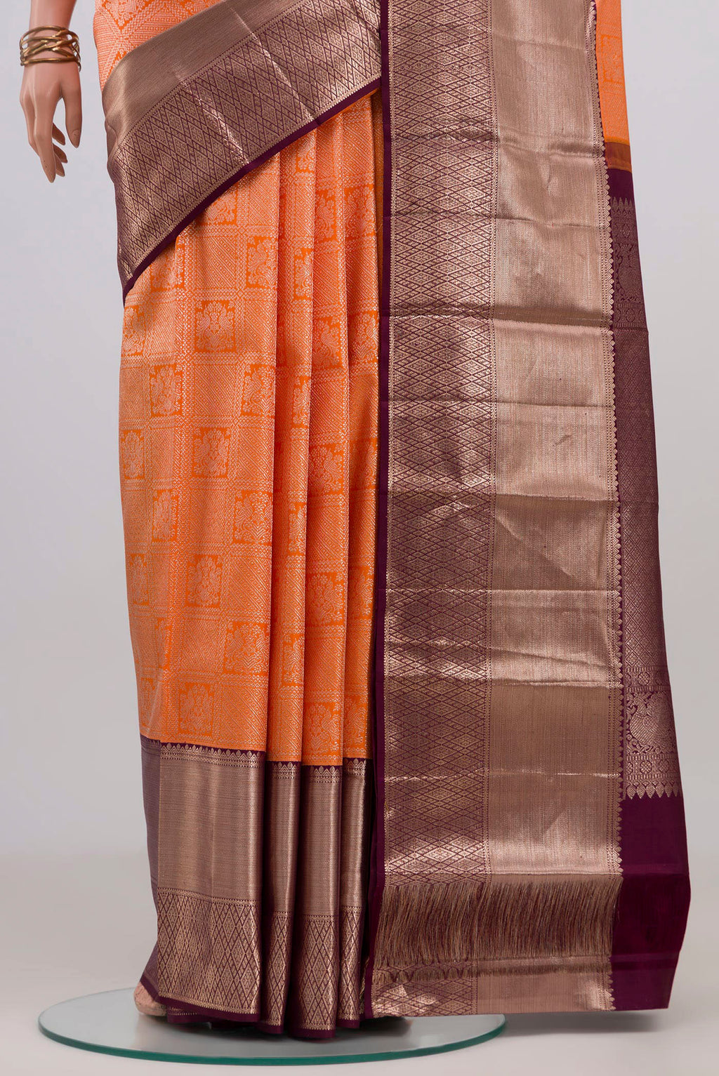 Pleats and pallu of Orange Kanchipuram Silk Saree with Zari Brocade on the body and Zari Border. 