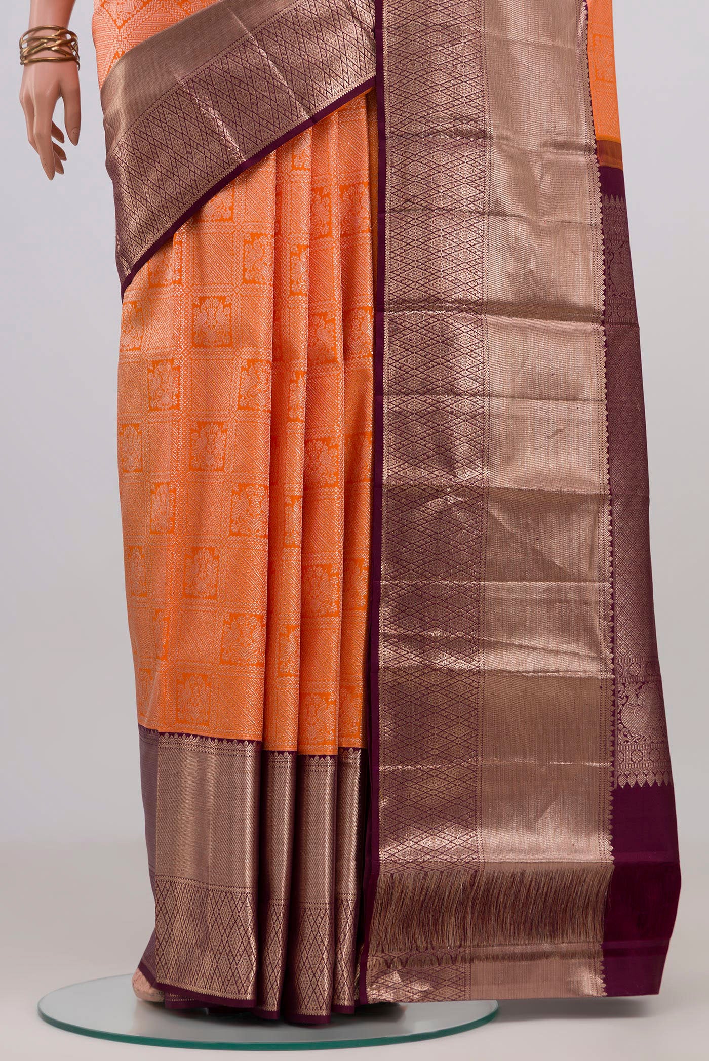 Pleats and pallu of Orange Kanchipuram Silk Saree with Zari Brocade on the body and Zari Border. 