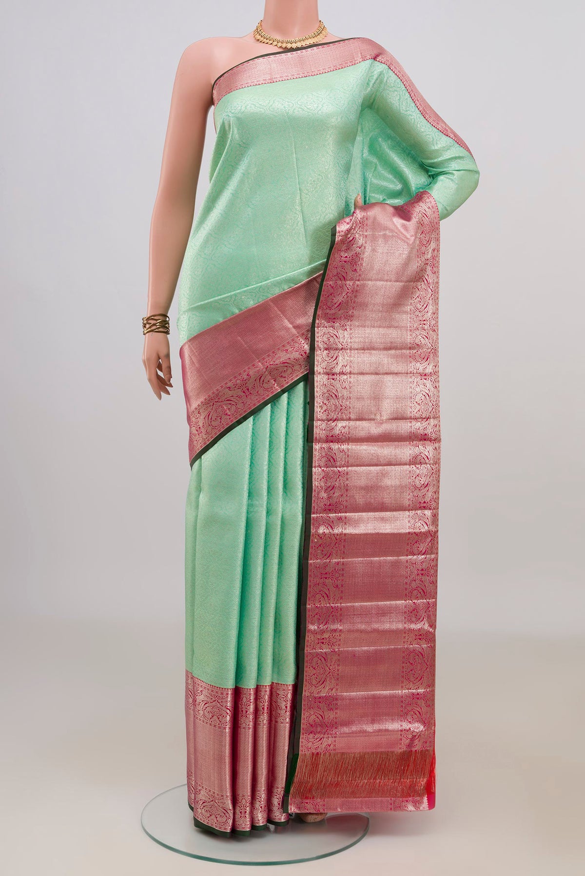 Pure Silk Mint Green Kanchipuram Saree with Zari Brocade on the body and Zari Border.  displayed on a mannequin