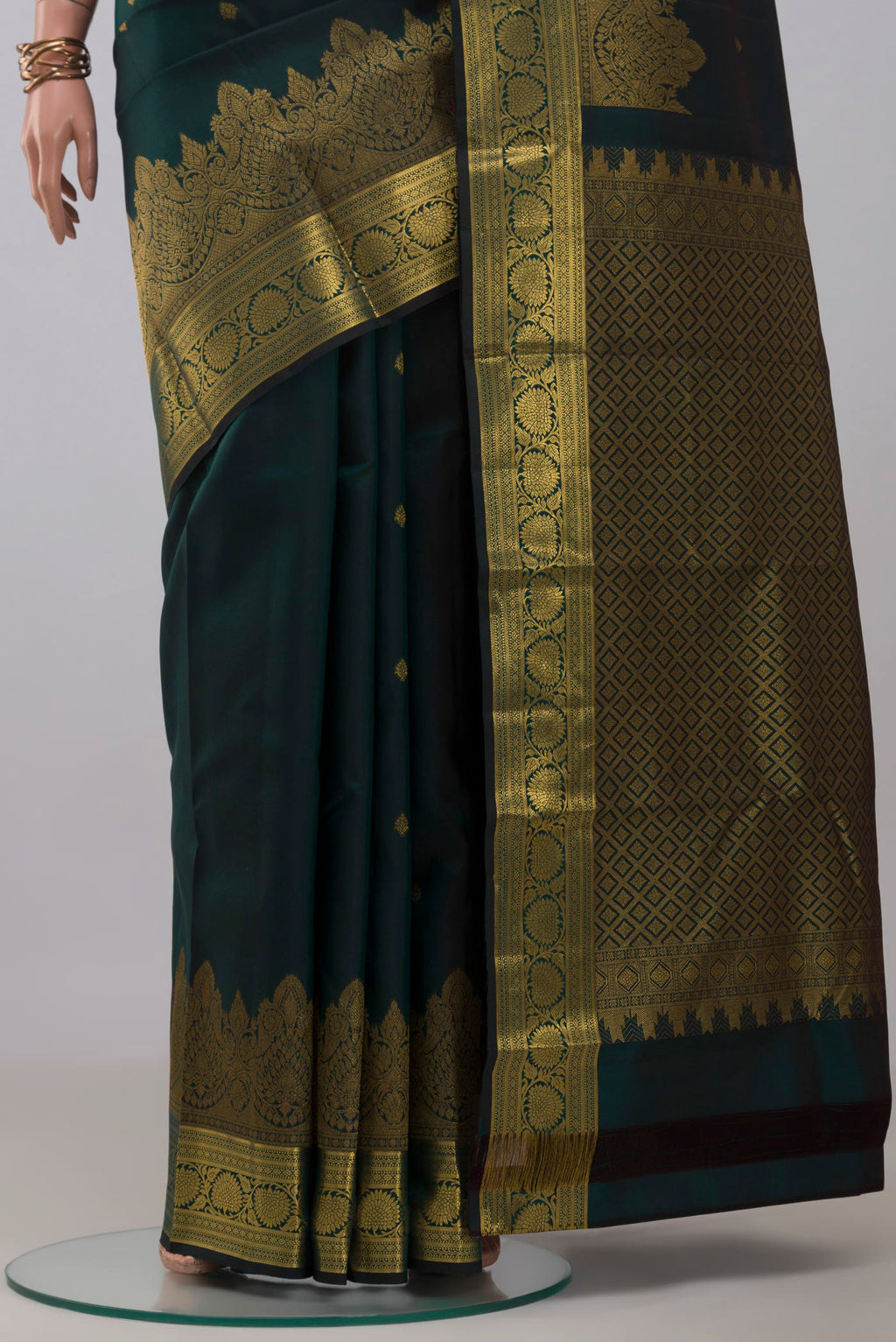 Pleats and pallu of Bottle Green Kanchipuram Silk Saree with Zari Butta on the body and Zari Border. 