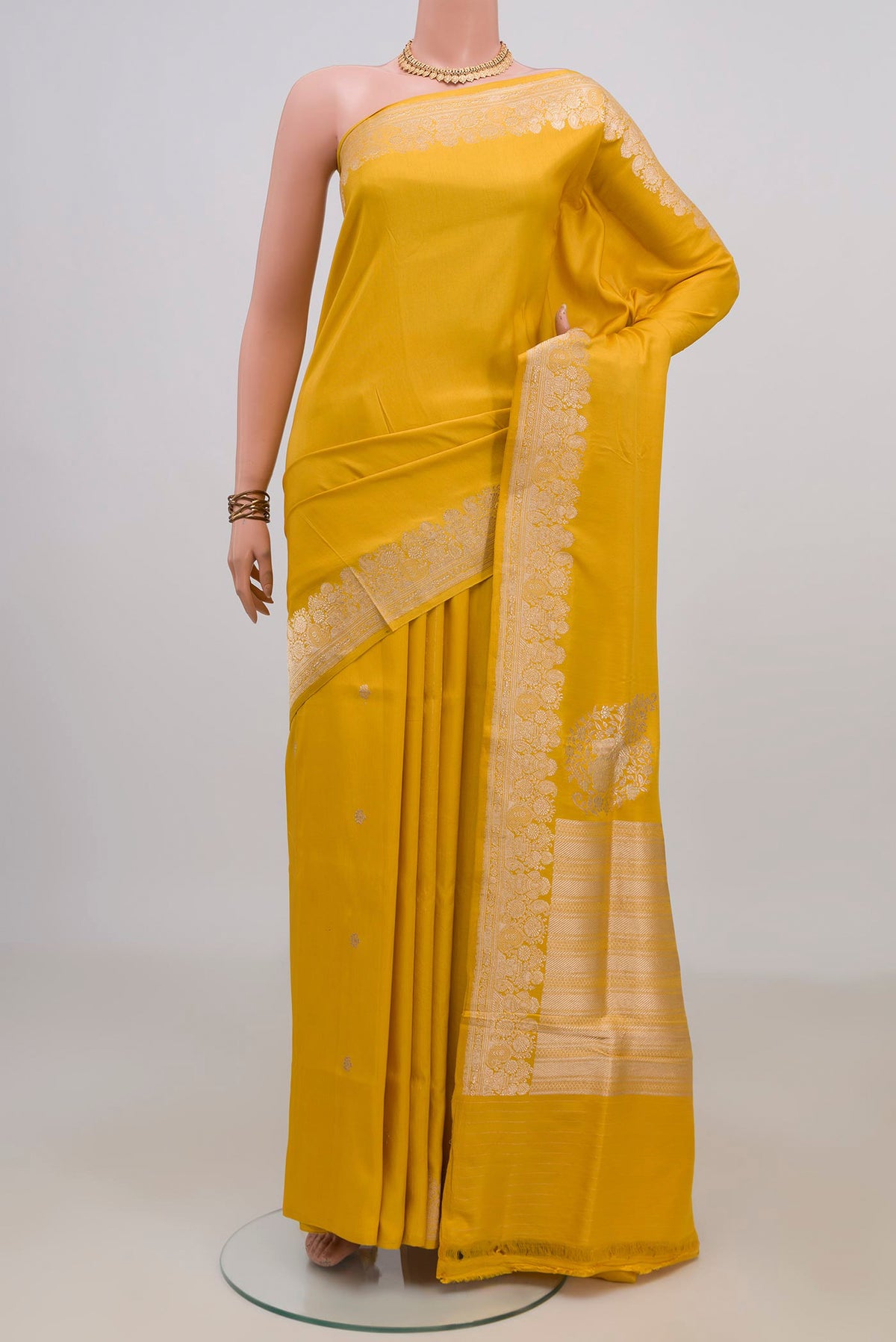 Pure Silk Yellow Banarasi Saree with Plain Body and Fancy Border.  displayed on a mannequin
