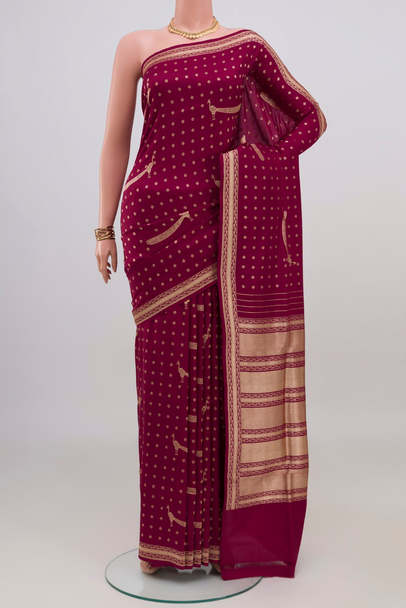 Maroon Banarasi Silk Saree with Zari Butta on the body and Fancy Border.  displayed on a mannequin