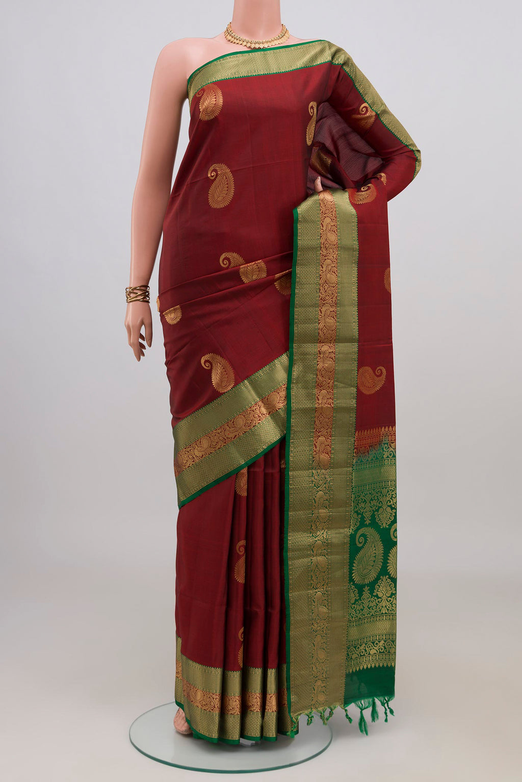 Maroon Soft Silk Saree with Zari Butta on the body and Zari Border.  displayed on a mannequin