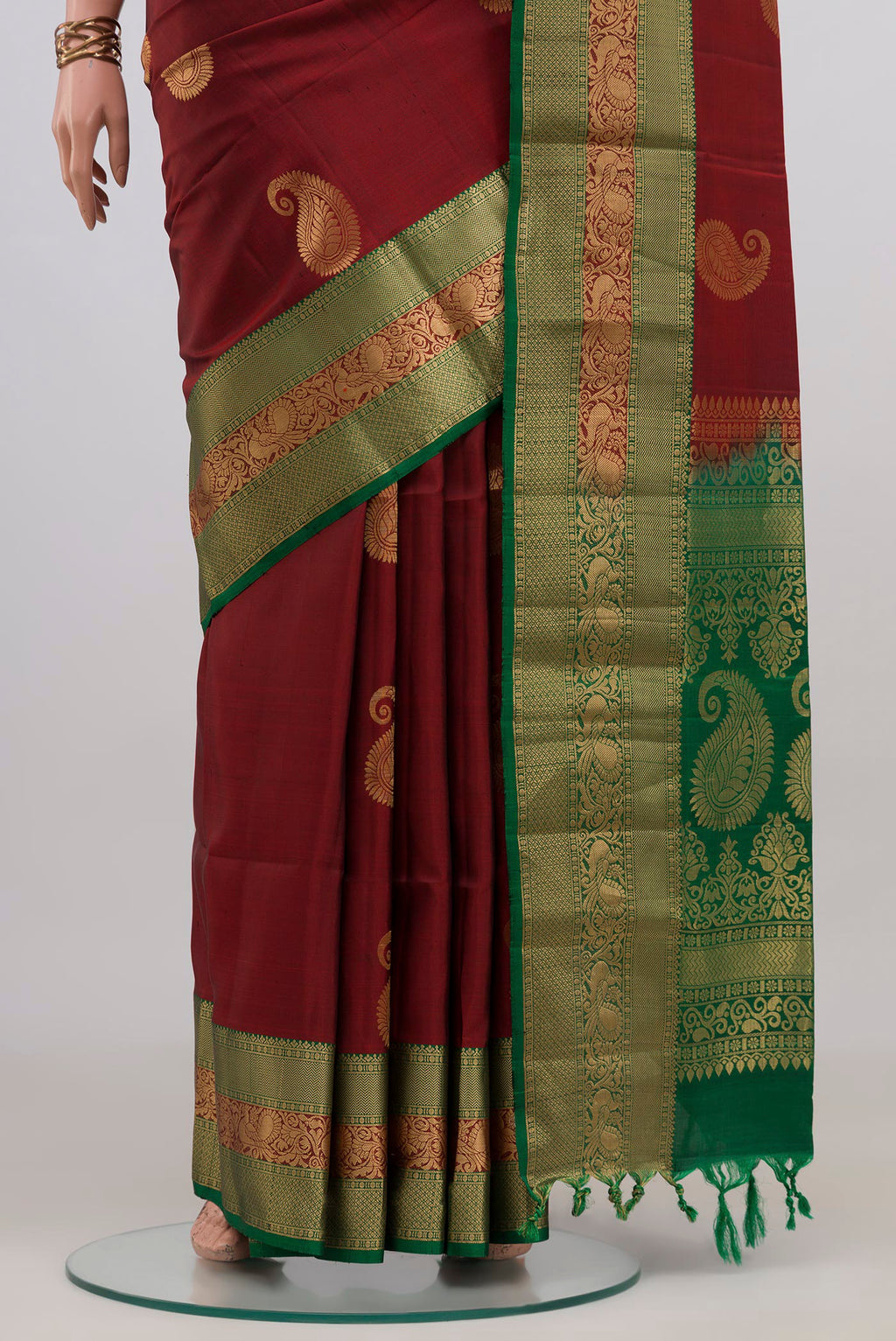 Pleats and pallu of Maroon Soft Silk Saree with Zari Butta on the body and Zari Border. 
