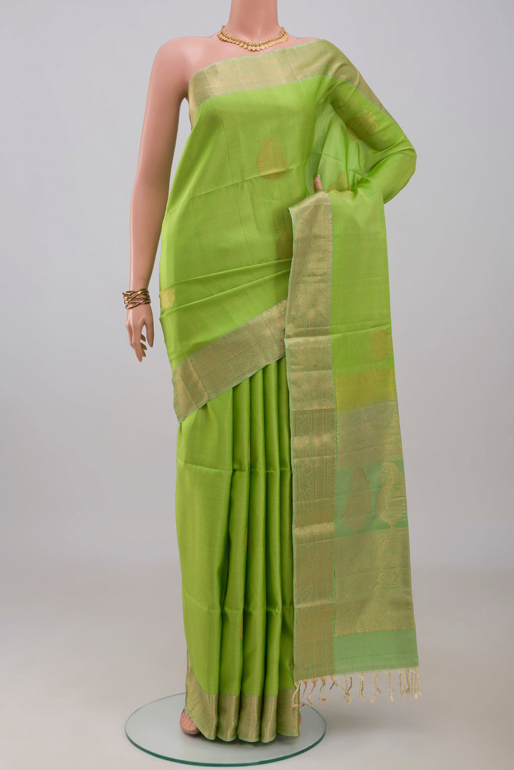 Light Green Soft Silk Saree with Zari Butta on the body and Zari Border.  displayed on a mannequin