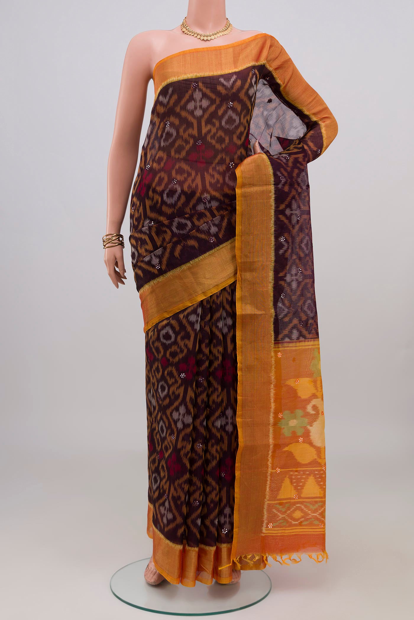 Coffee Brown Silk Cotton Saree with Ikat design on the body and Zari Border.  displayed on a mannequin