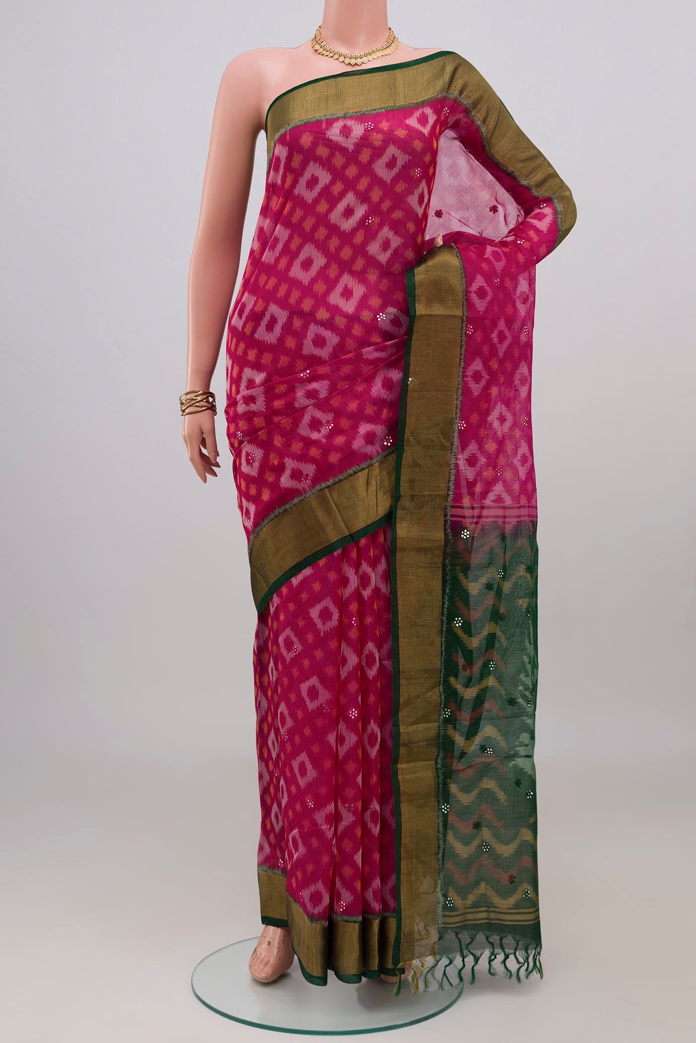 Pink Silk Cotton Saree with Ikat design on the body and Zari Border.  displayed on a mannequin