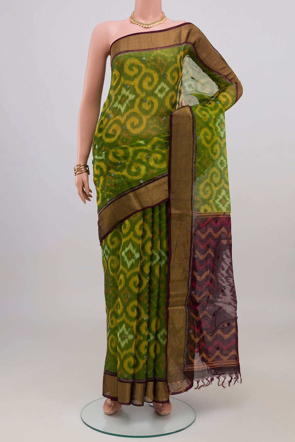 Green Silk Cotton Saree with Ikat Print on the body and Zari Border.  displayed on a mannequin