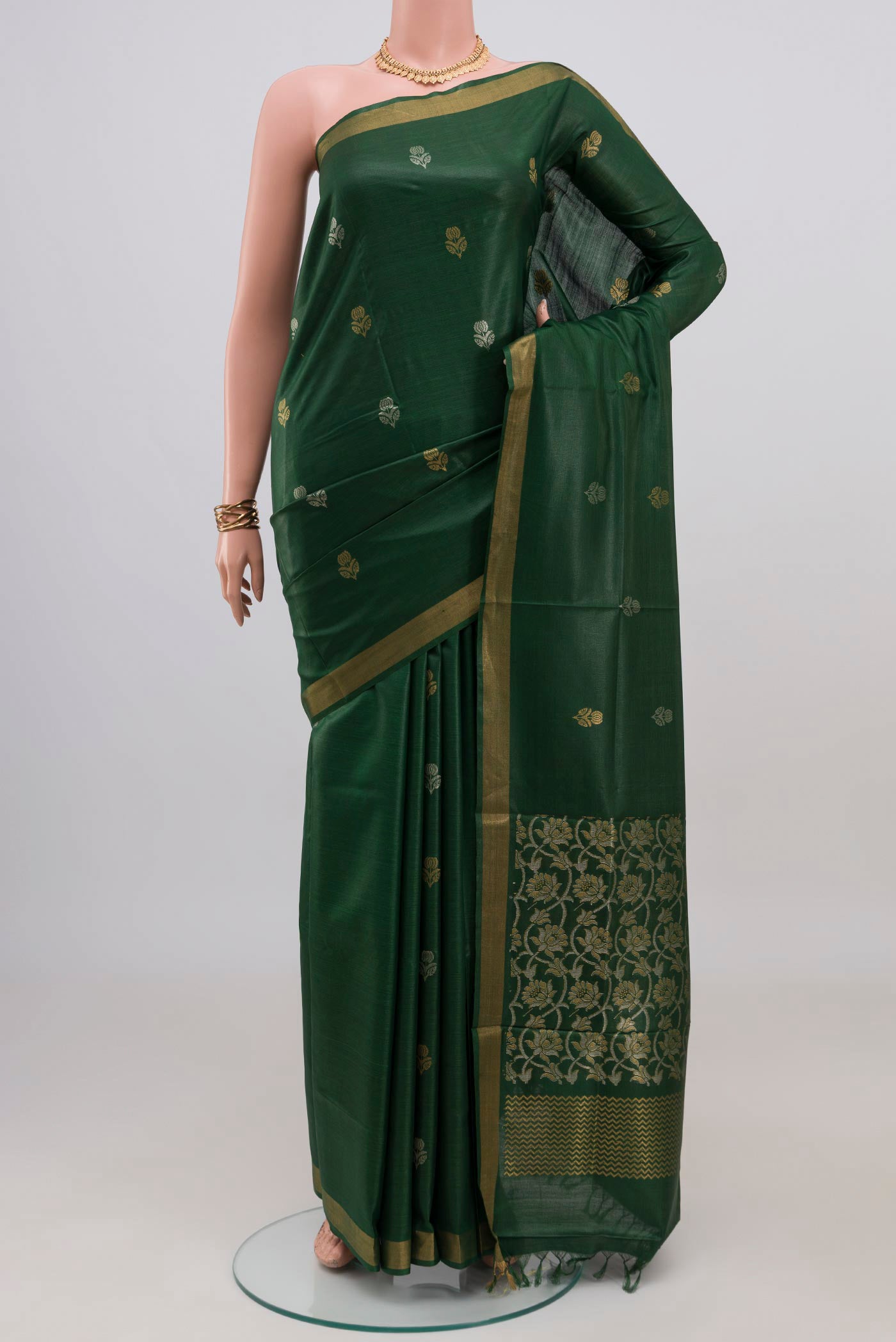 Bottle Green Tussar Silk Saree with Zari Butta on the body and Zari Border.  displayed on a mannequin