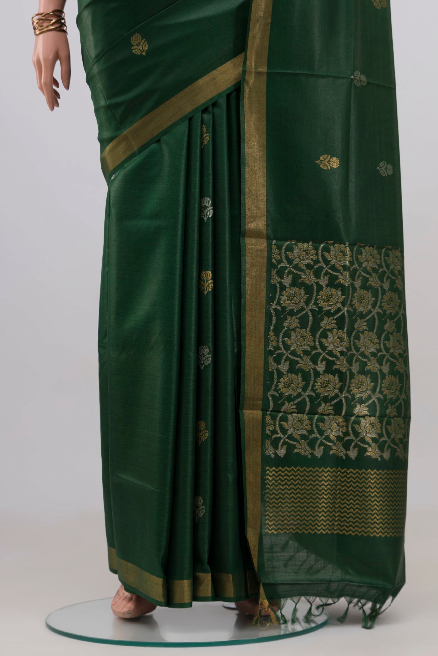 Pleats and pallu of Bottle Green Tussar Silk Saree with Zari Butta on the body and Zari Border. 