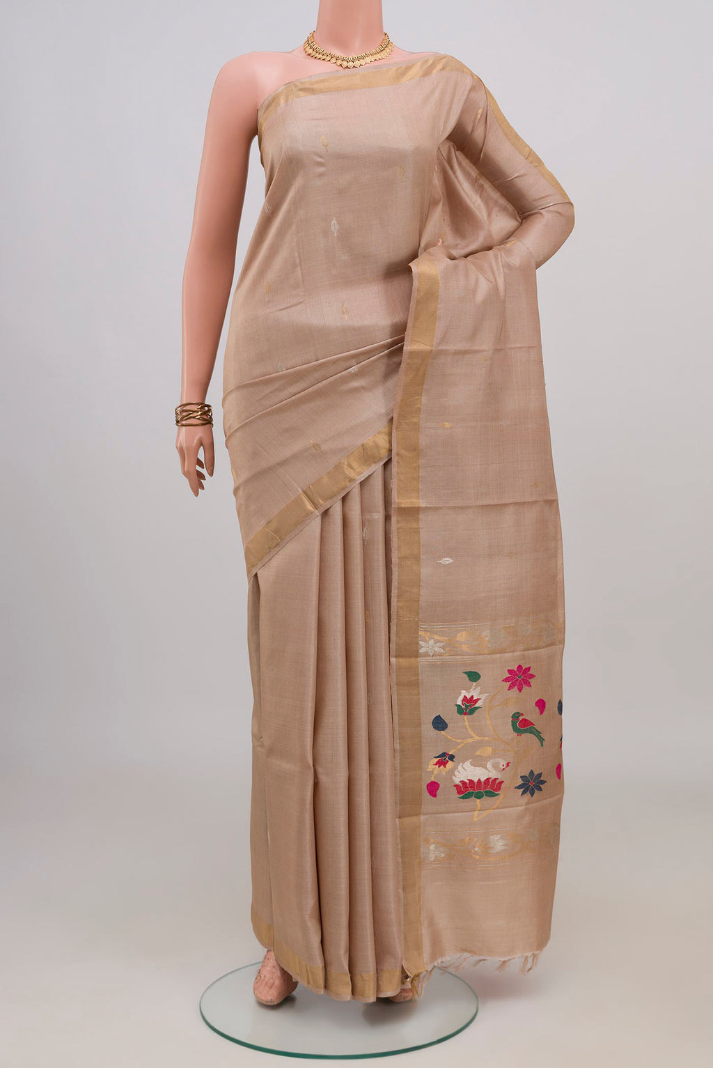 Beige Tussar Silk Saree with Zari Butta on the body and Zari Border.  displayed on a mannequin