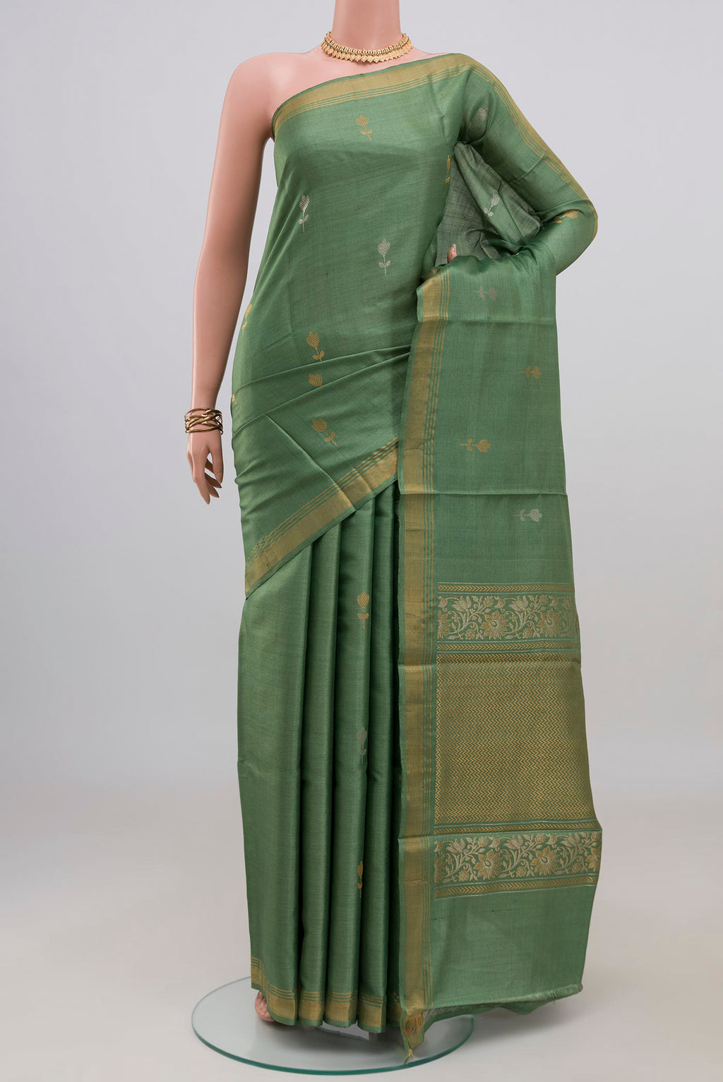 Sage Green Tussar Silk Saree with Zari Butta on the body and Zari Border.  displayed on a mannequin