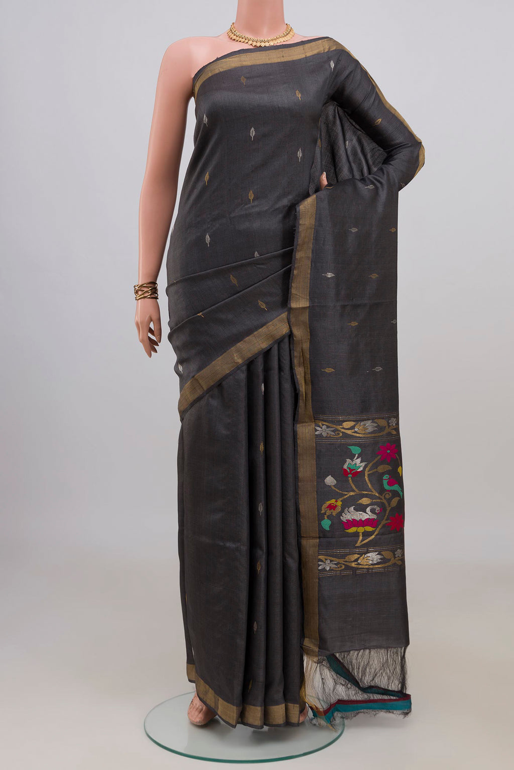 Grey Tussar Saree with Zari Butta on the body and Zari Border.  displayed on a mannequin