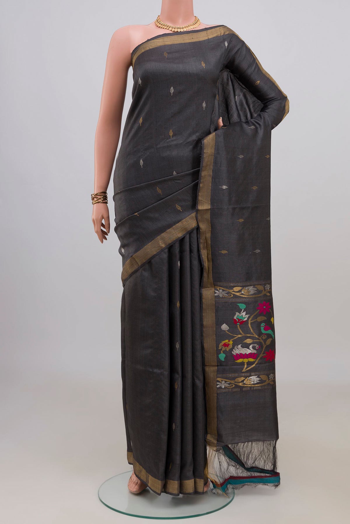 Grey Tussar Saree with Zari Butta on the body and Zari Border.  displayed on a mannequin