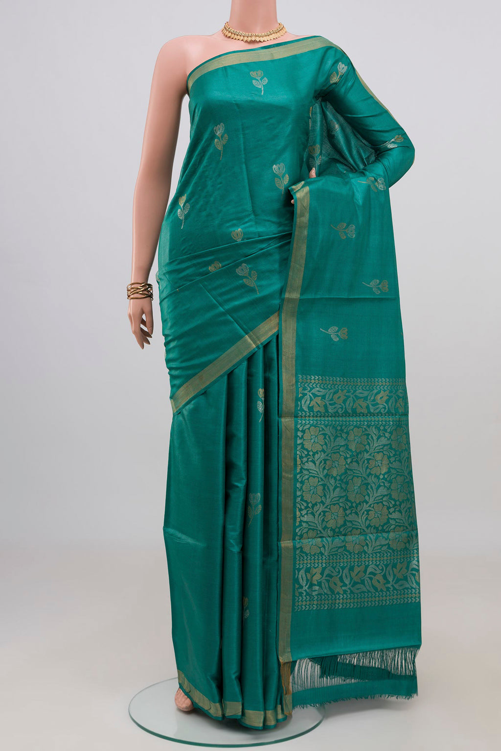 Teal Tussar Silk Saree with Zari Butta on the body and Zari Border.  displayed on a mannequin