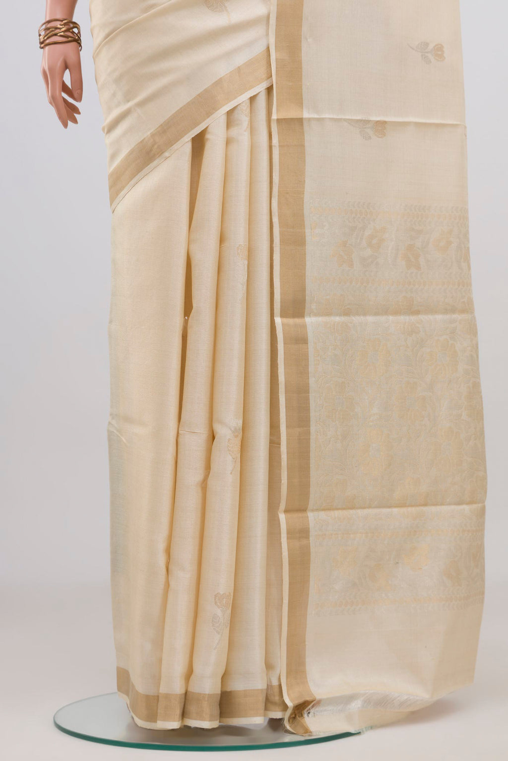 Pleats and pallu of Cream Tussar Silk Saree with Zari Butta on the body and Zari Border. 