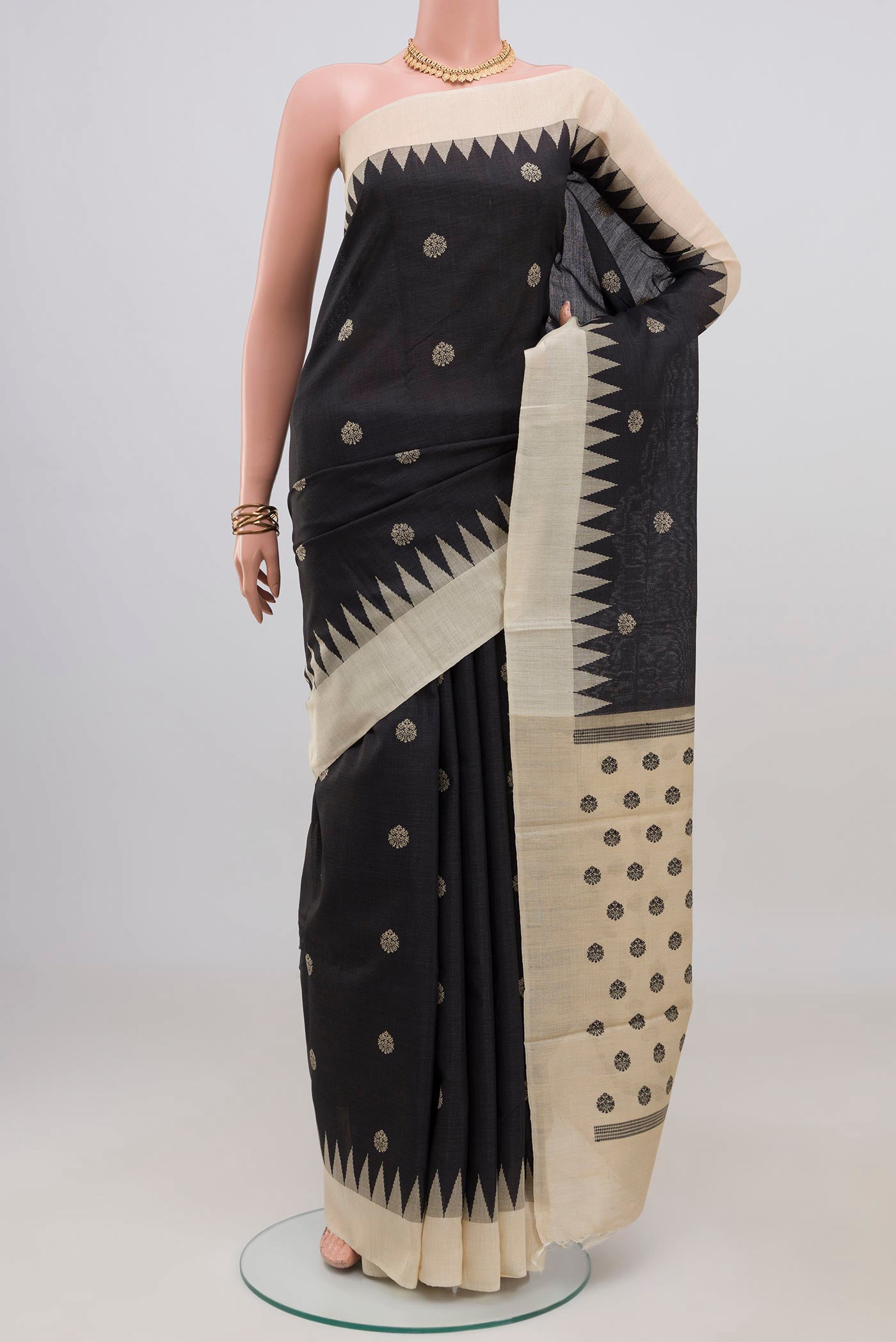 Black Tussar Silk Saree with Thread Butta on the body and Temple Border.  displayed on a mannequin